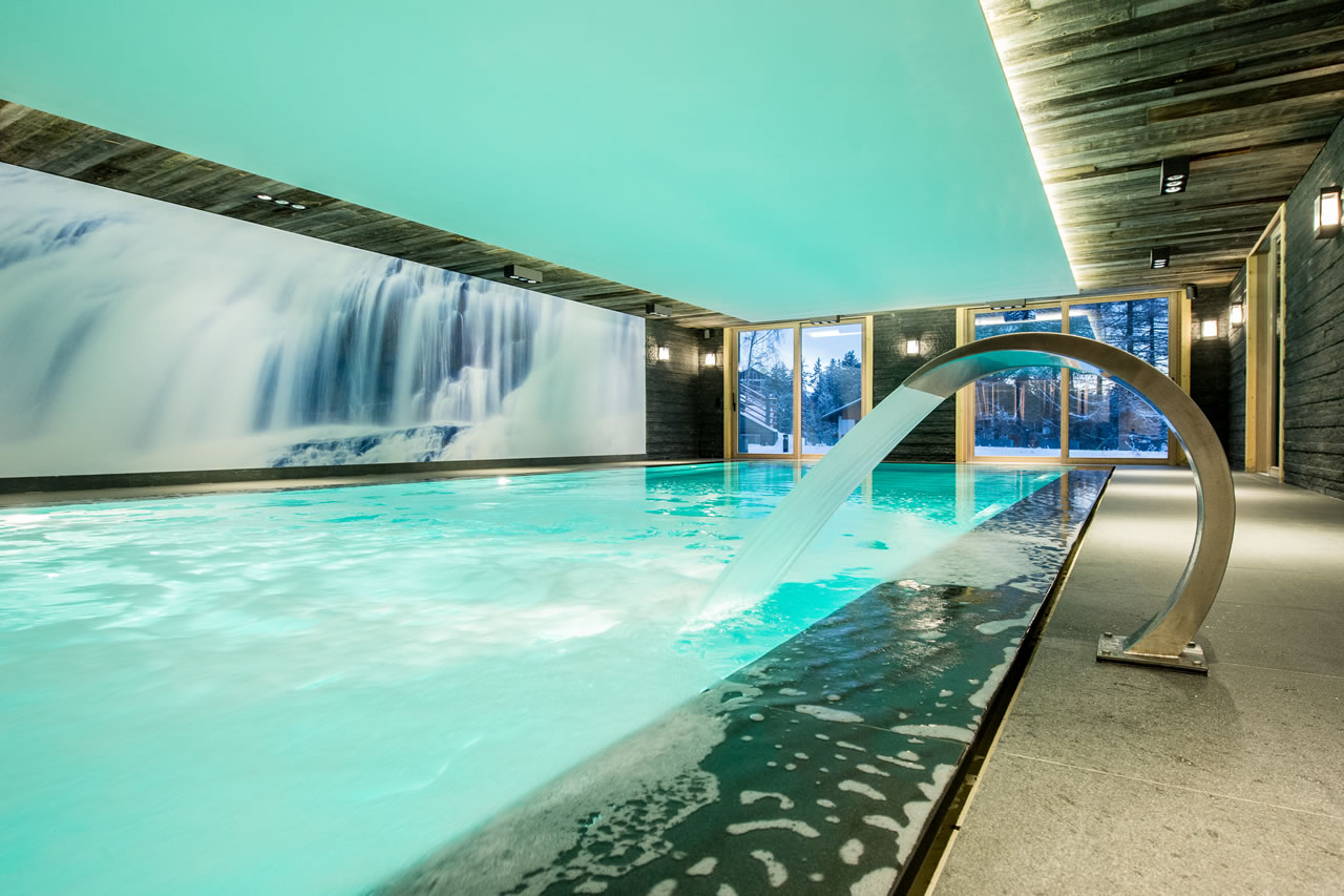 Indoor pool with fountain feature in Chalet Migui in Crans-Montana