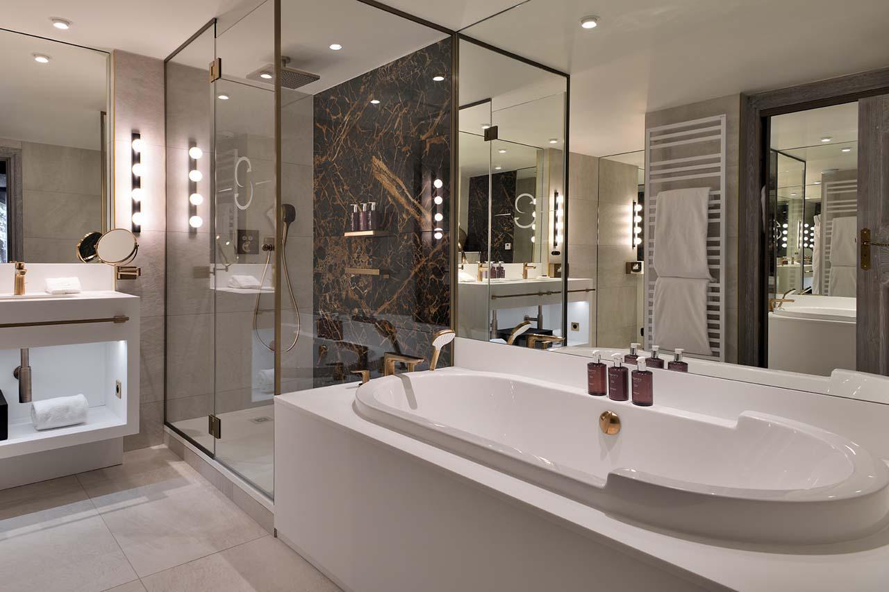 En-suite bathroom with bath and shower at Apartment Ariondaz in Courchevel 1850