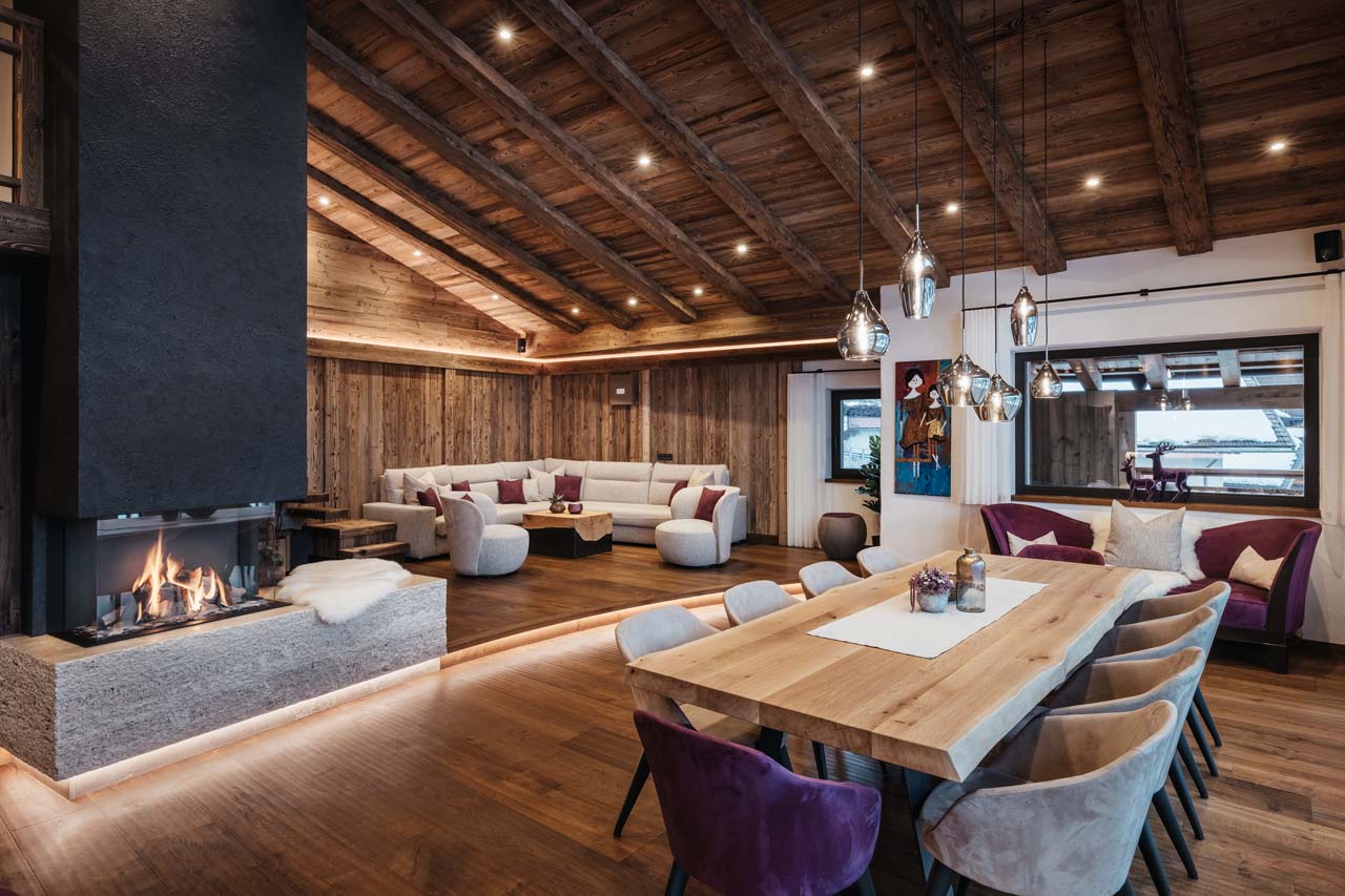 Central fireplace and large dining table in Chalet Lefiro, Val Gardena
