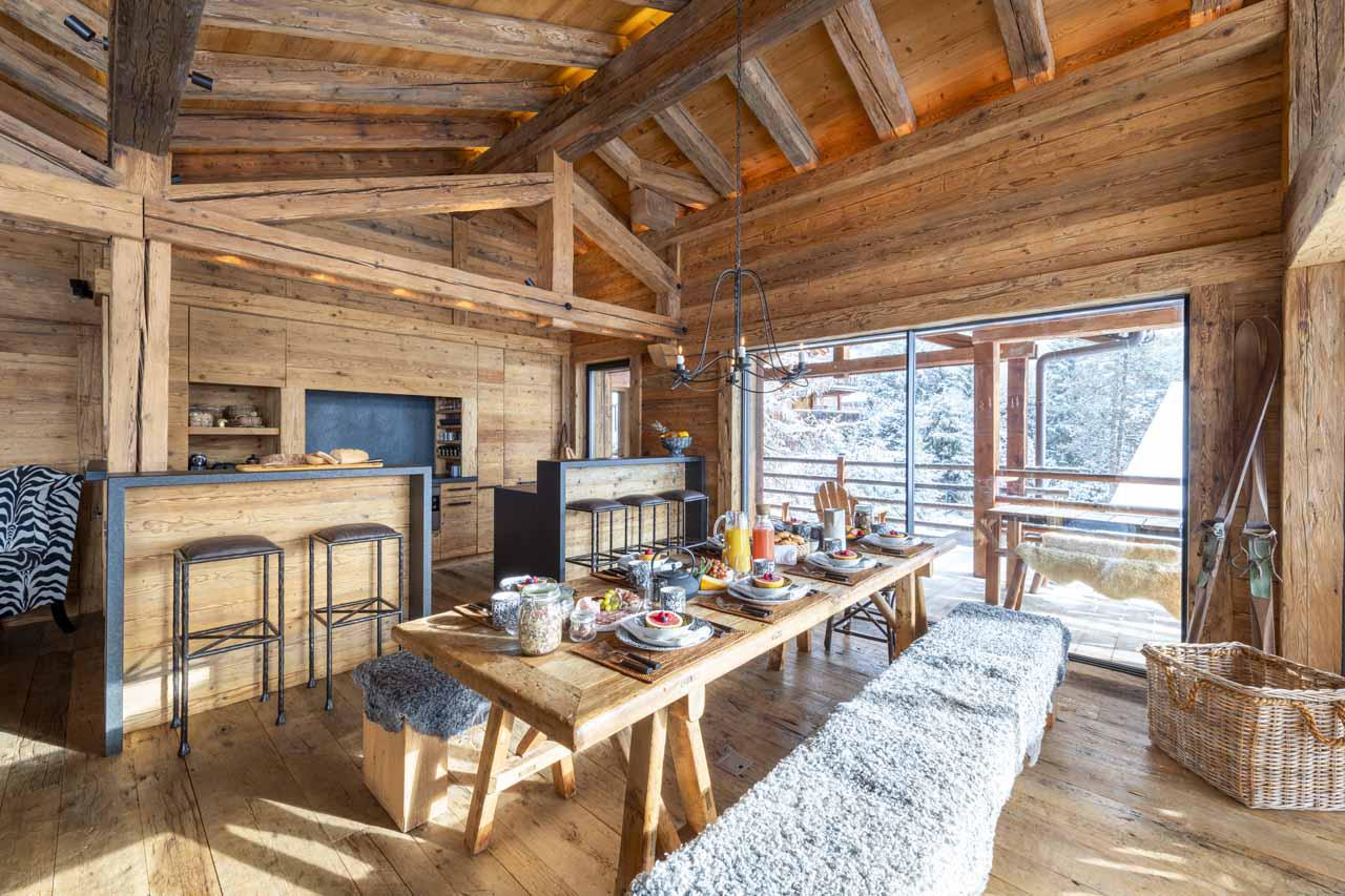Dining table and kitchen equipped with top-of-the-range appliances at Marmotte Penthouse in Verbier
