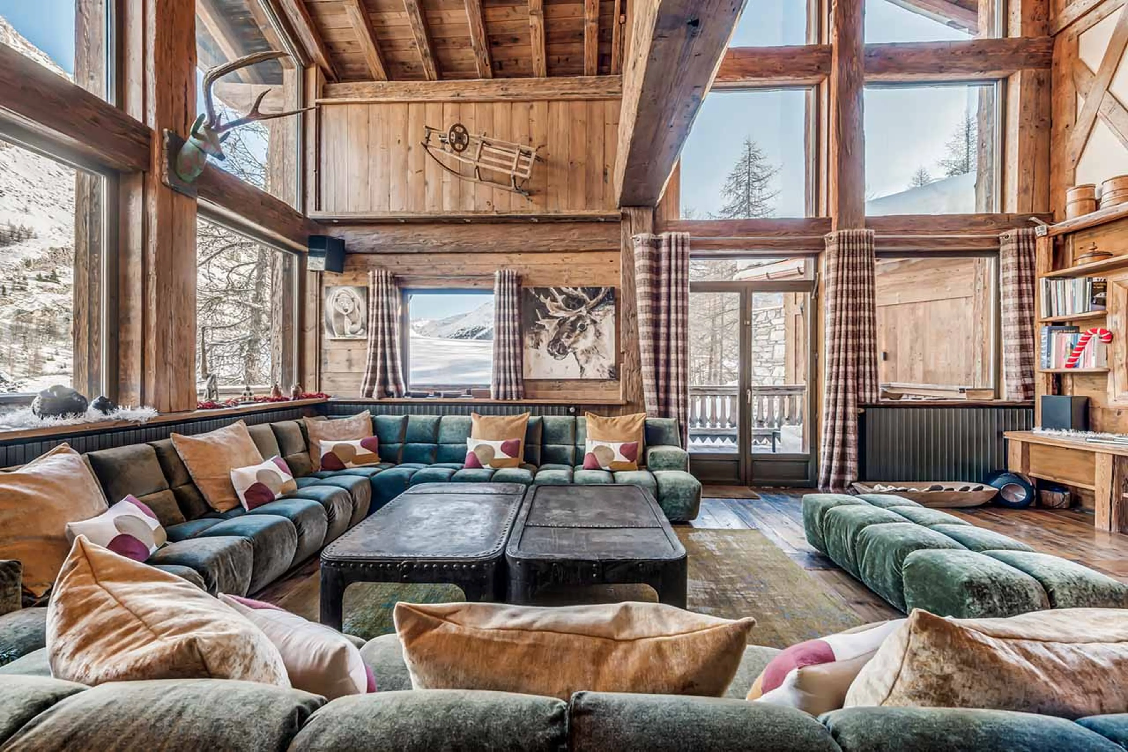 Old wood combined with crystal chandeliers in living area of Chalet Le Rocher in Val d’Isere