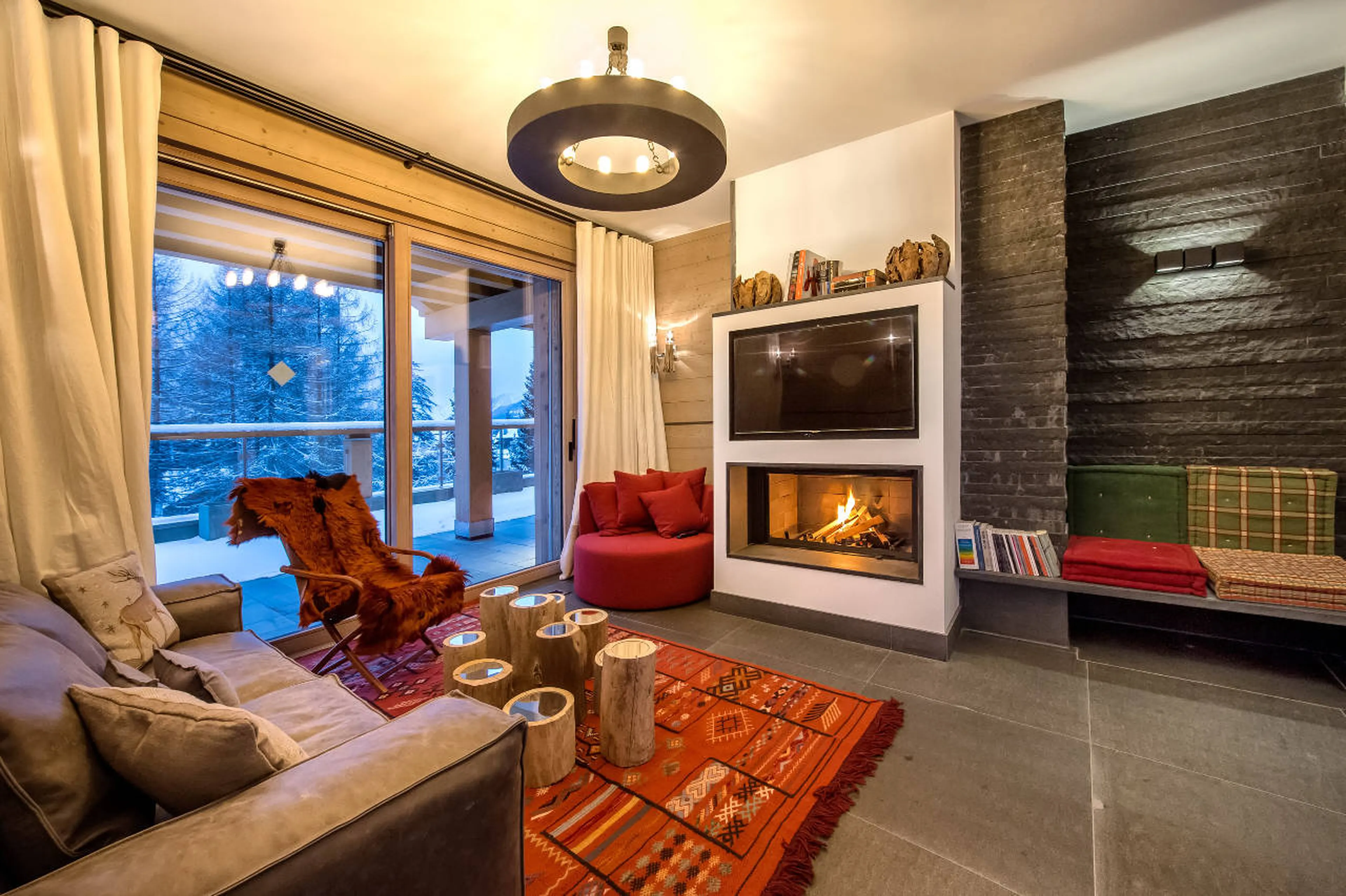 Living room with fireplace and terrace access in Apartment Aminona in Crans-Montana