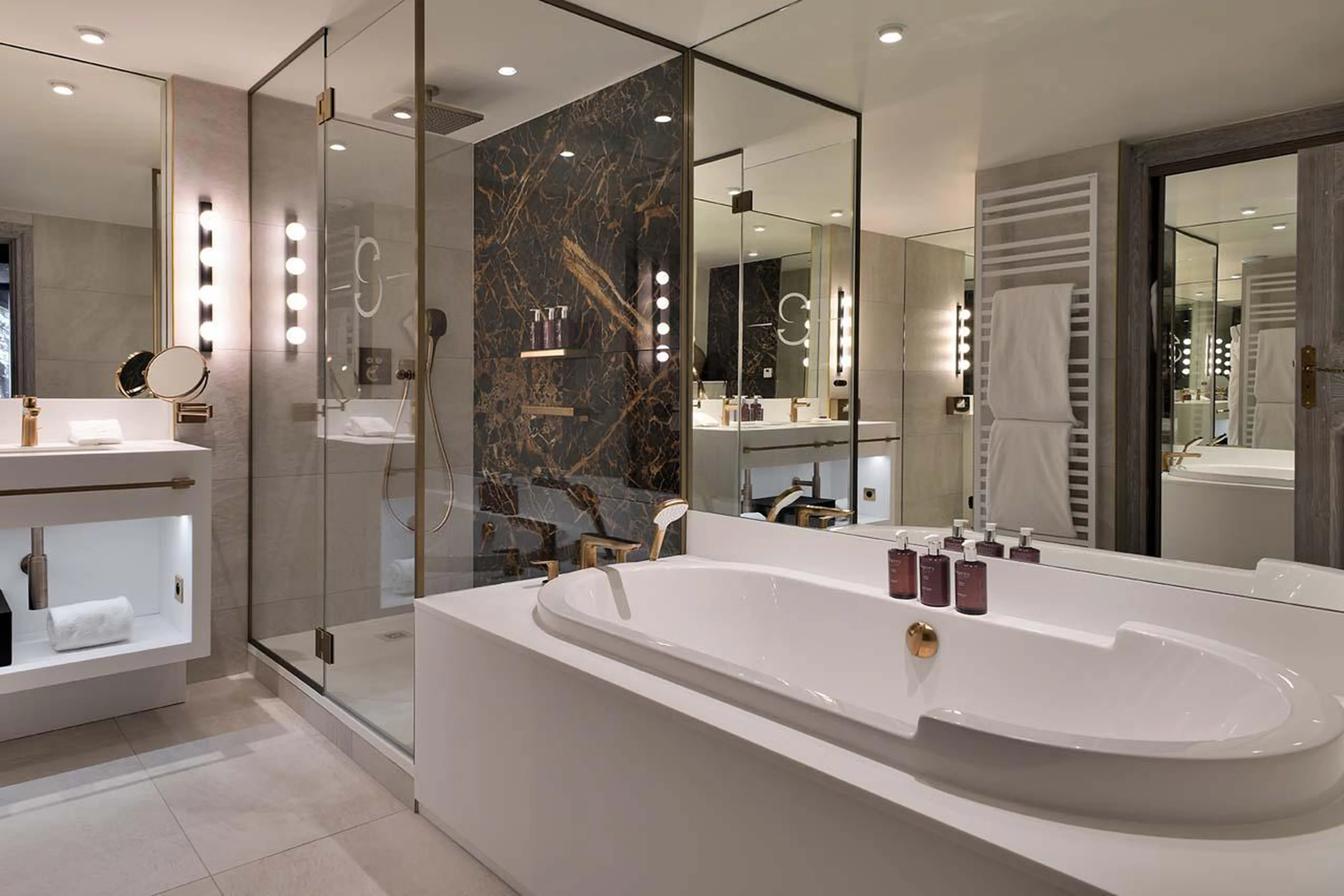 En-suite bathroom with bath and shower at Apartment Ariondaz in Courchevel 1850