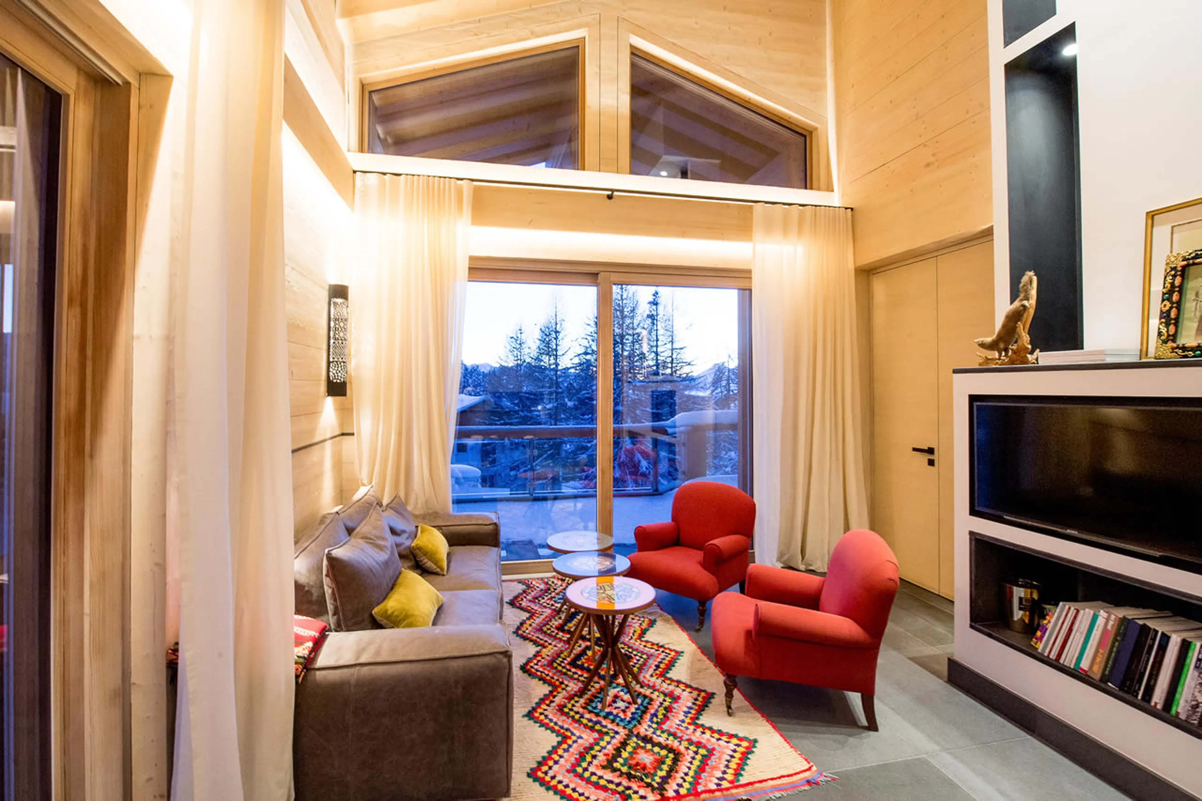 Living room with vaulted ceiling and balcony access in Apartment Bellalui in Crans-Montana