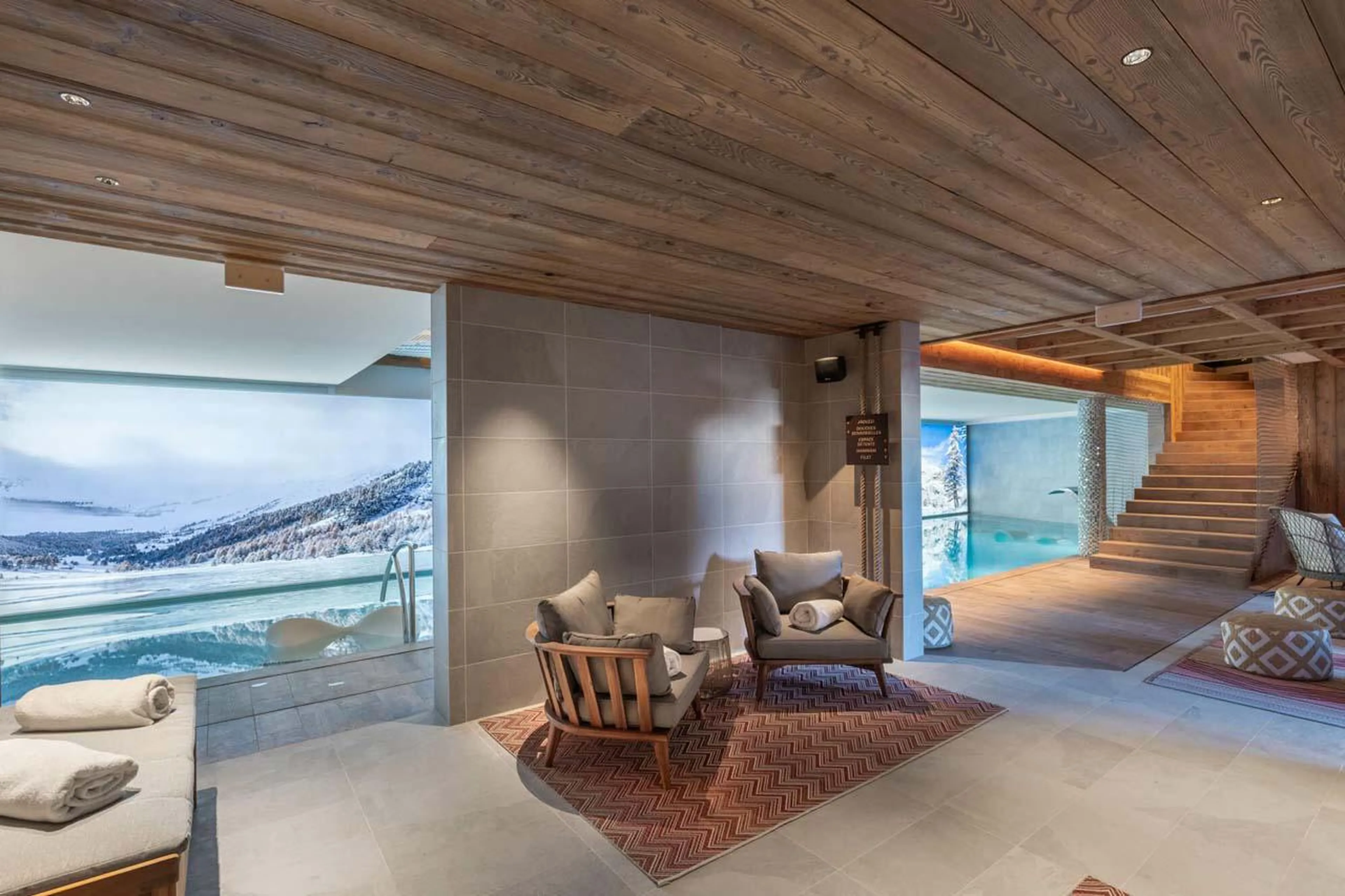 Spa with indoor swimming pool and poolside seating at Apartment Castano in Courchevel 1850