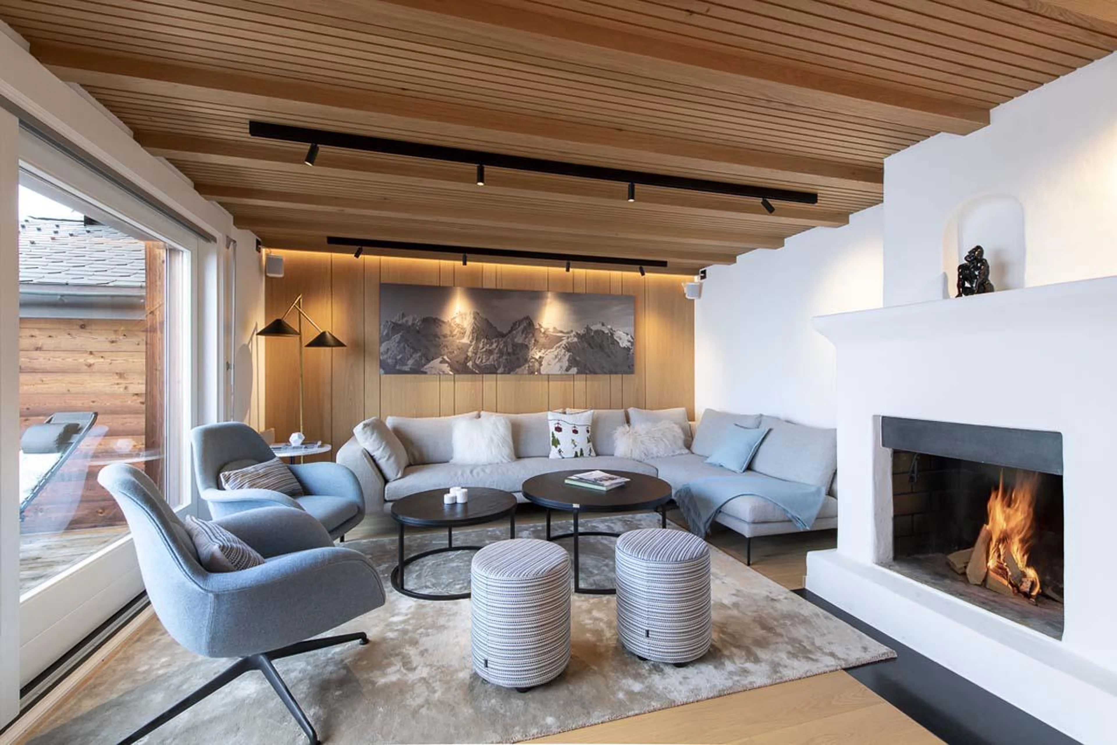 L-shaped sofa surrounding the wood-burning fireplace at Apartment Grignote in Verbier