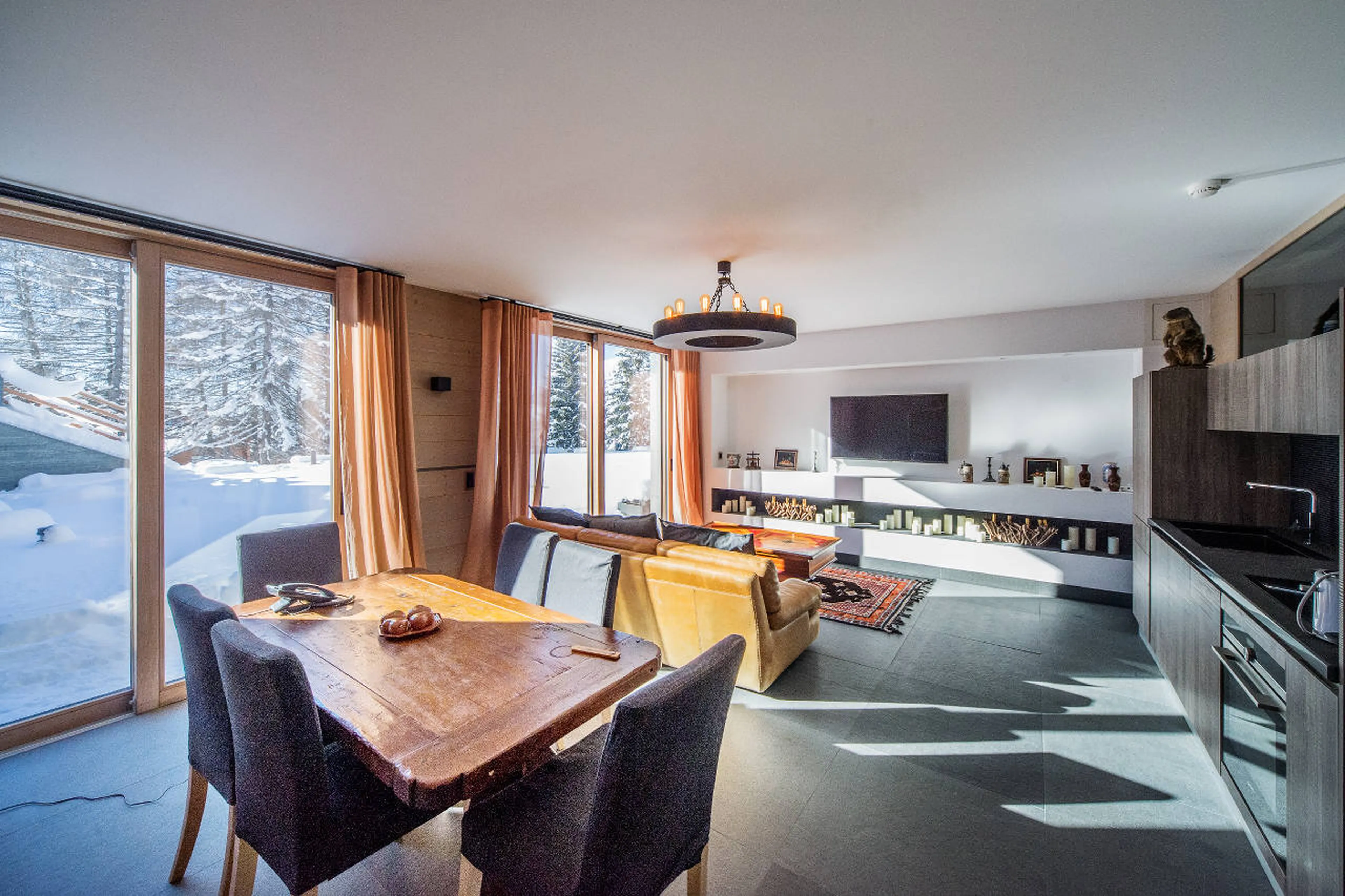Living, dining and kitchen area with terrace access in Apartment La Toula in Crans-Montana