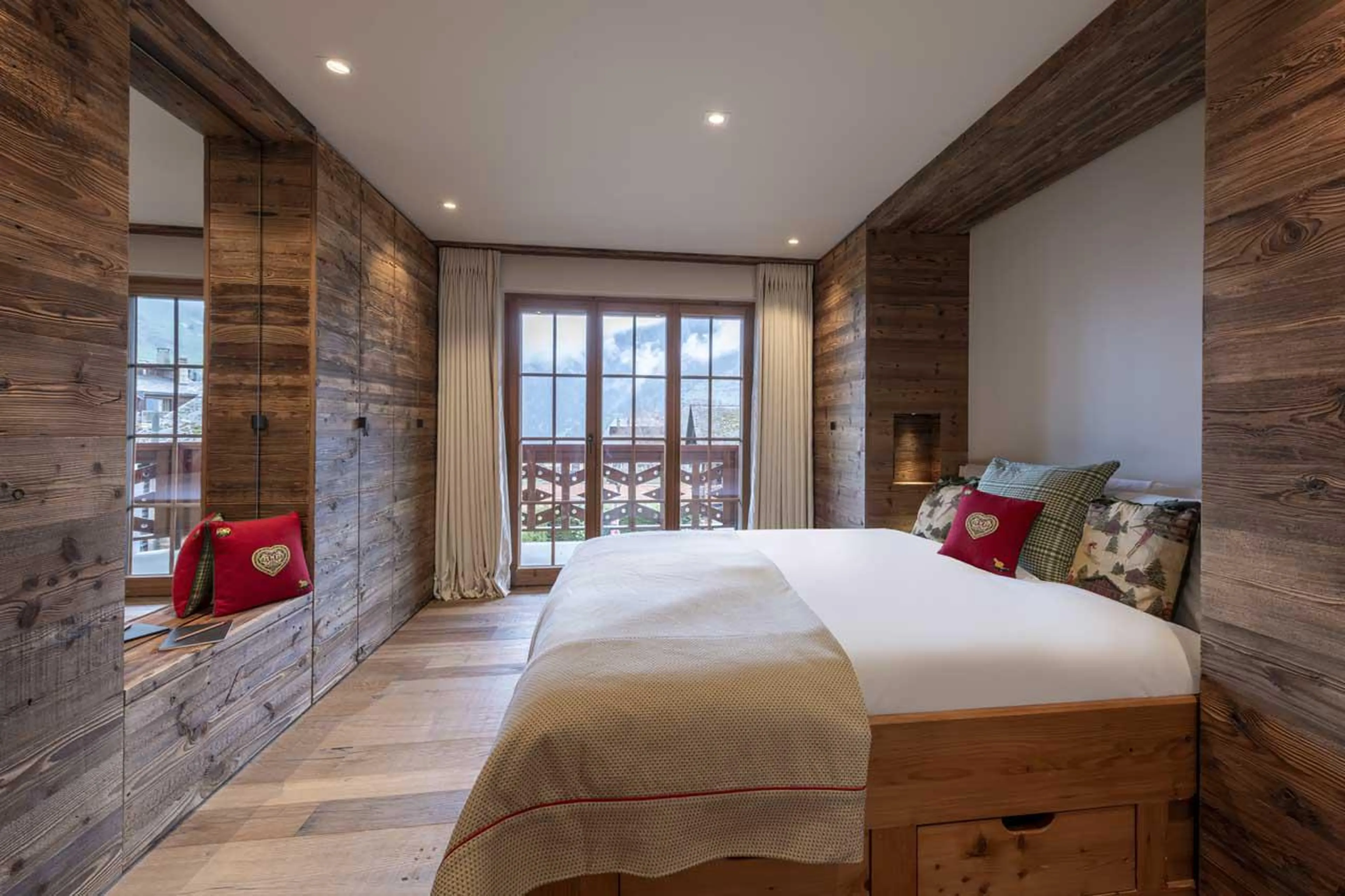 Double bedroom with balcony access and en-suite bathroom at Apartment Lussy in Verbier