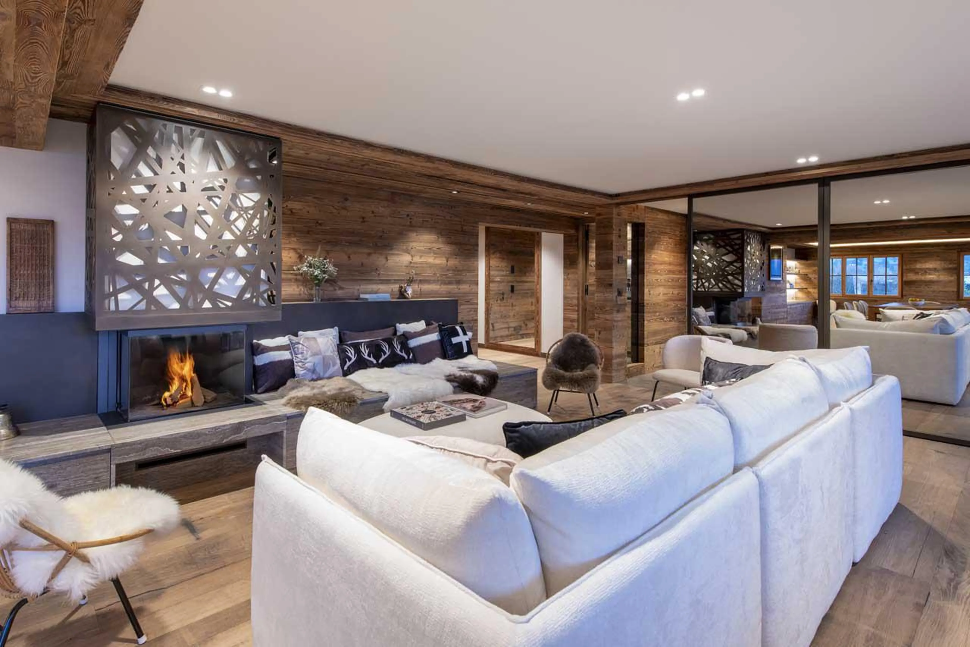 Sofas surrounding the wood-burning fireplace at Apartment Lussy in Verbier