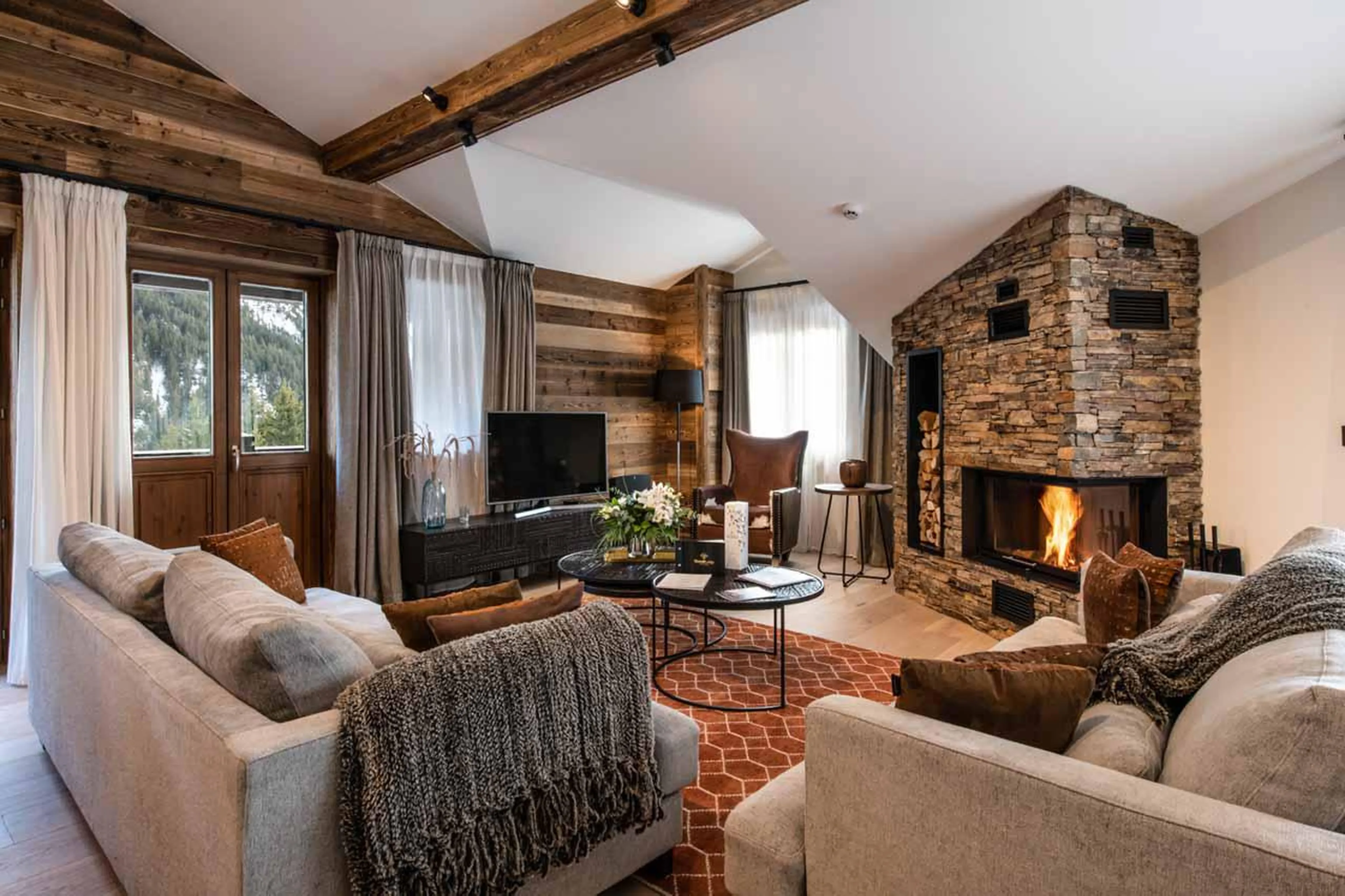 Open-plan living area with TV and fireplace at Apartment Makalu in Courchevel 1650