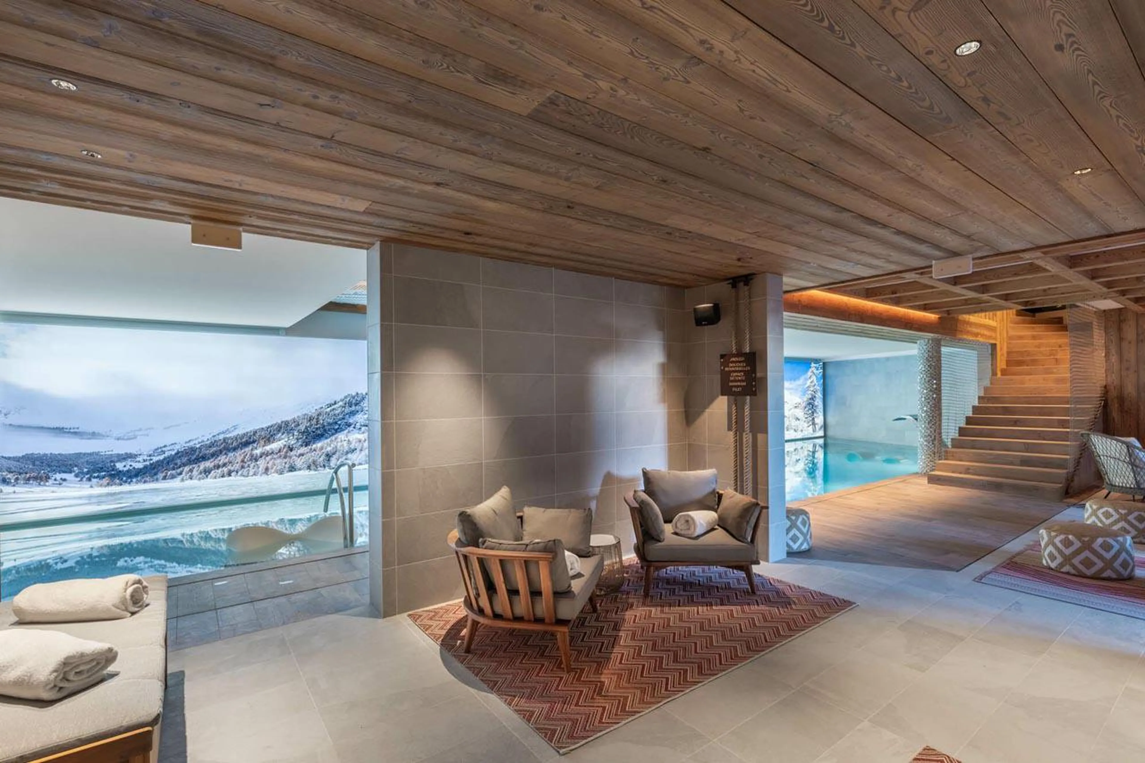 Spa with indoor swimming pool and poolside seating at Apartment Oro in Courchevel 1850