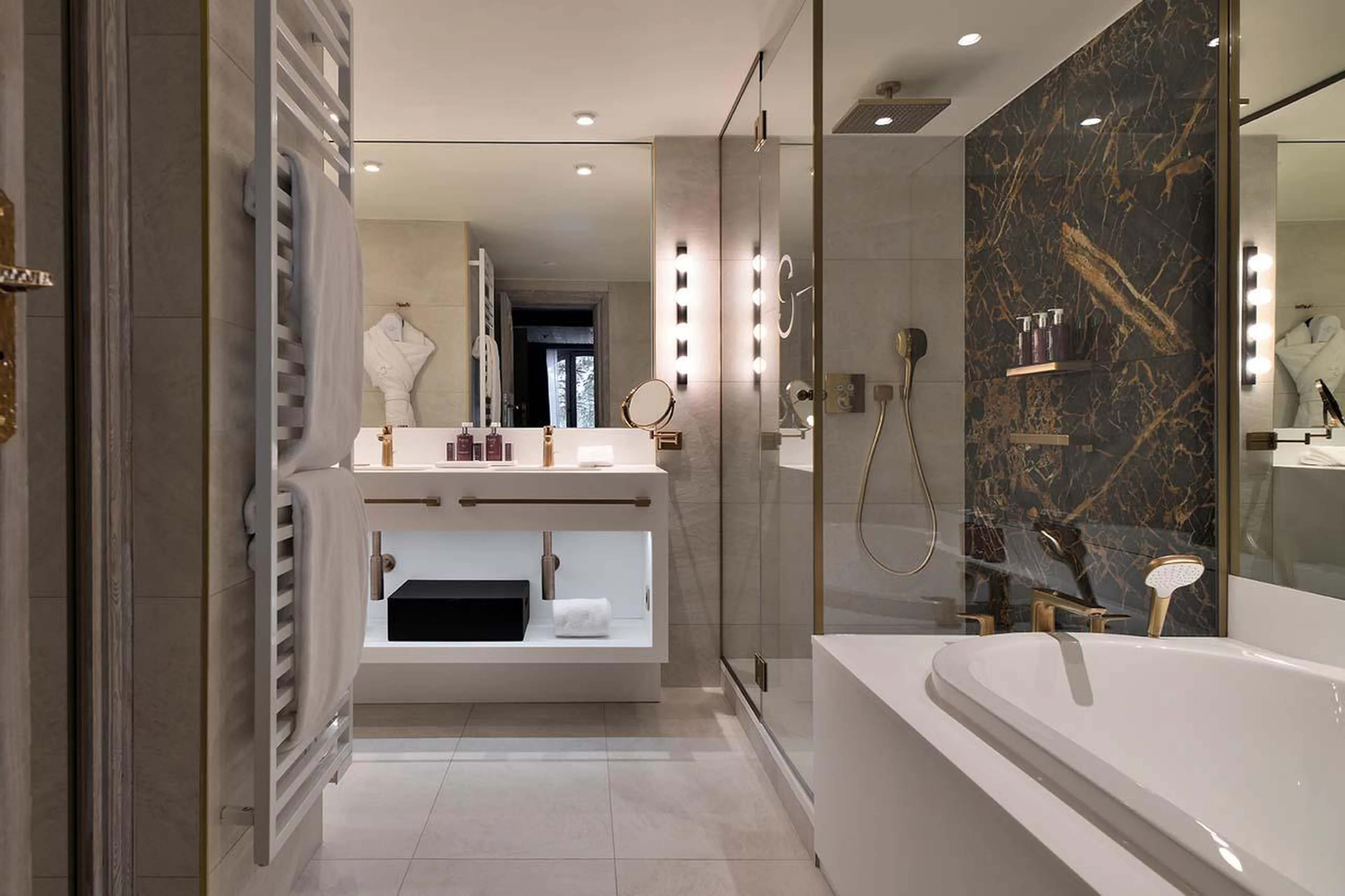 En-suite bathroom with bath and shower at Apartment Pyramides in Courchevel 1850