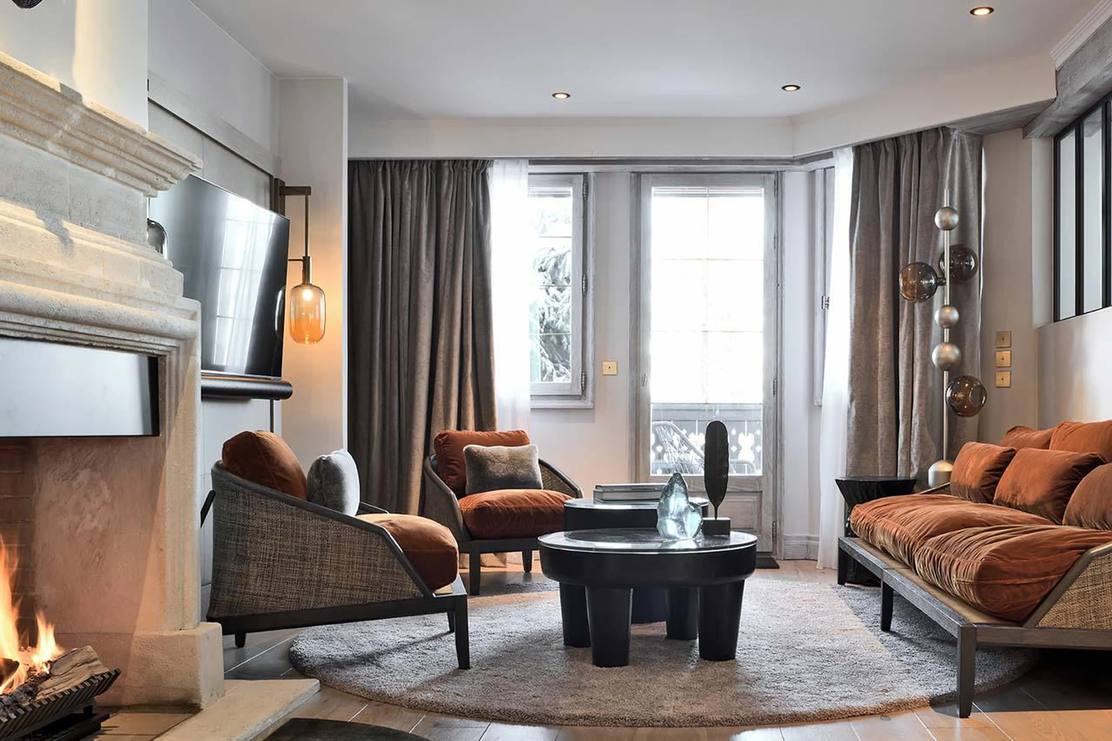 Open-plan living room with wood-burning fireplace at Apartment Pyramides in Courchevel 1850