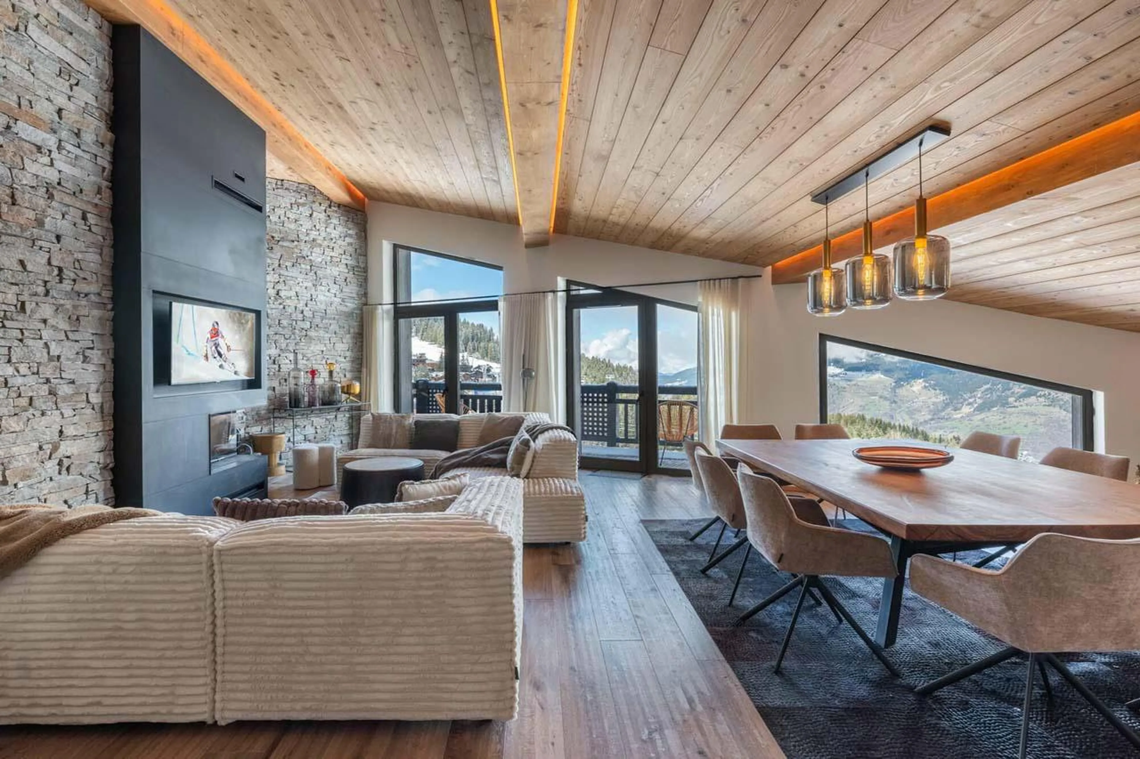 Open-plan living area with sofa space and dining table at Apartment Sirio in Courchevel 1850