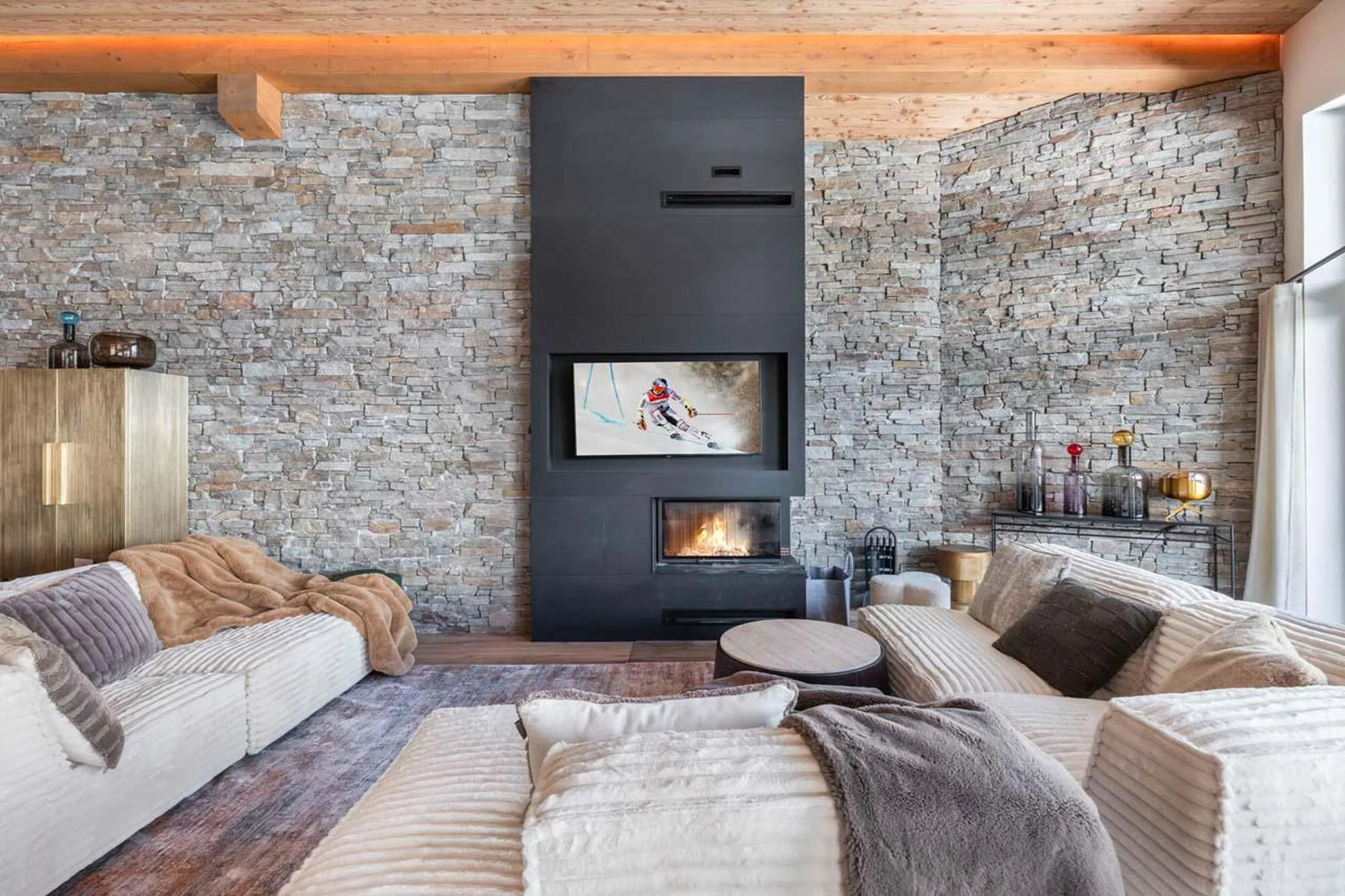 Sofas surrounding TV and fireplace at Apartment Sirio in Courchevel 1850