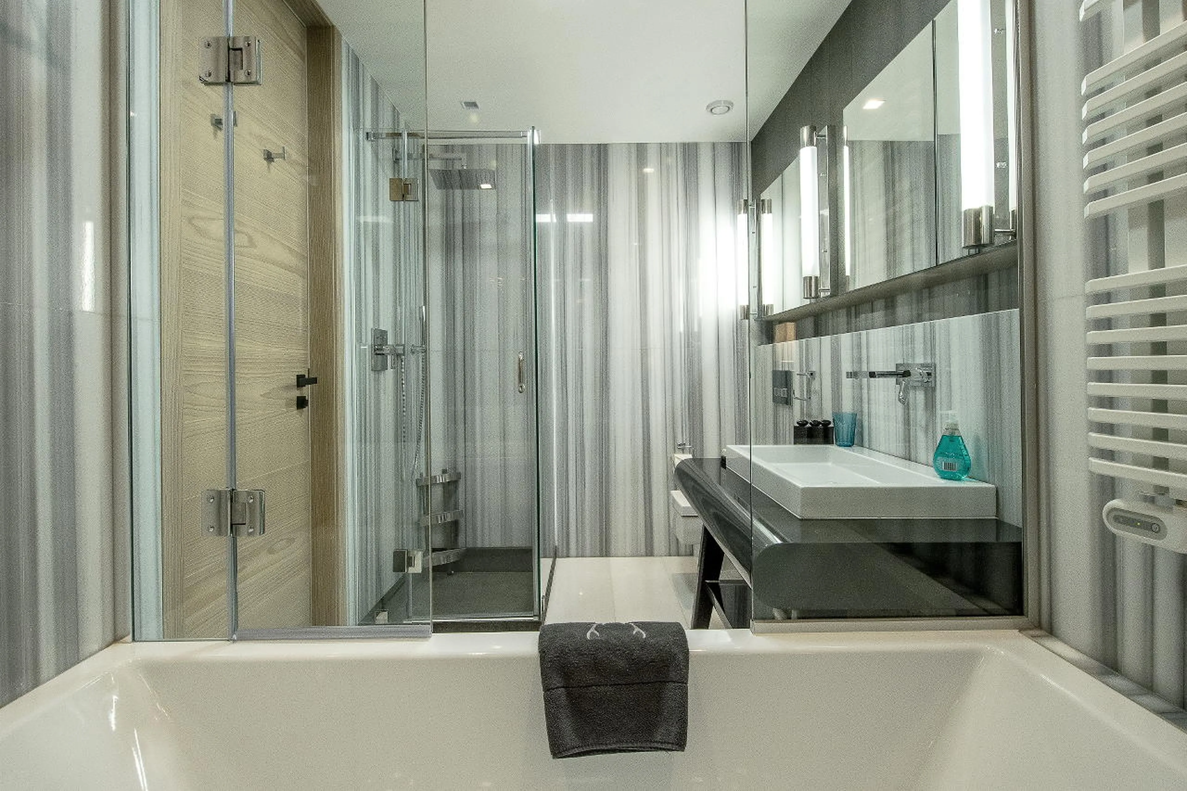 En-suite bathroom with bath and shower in Apartment Violettes in Crans-Montana