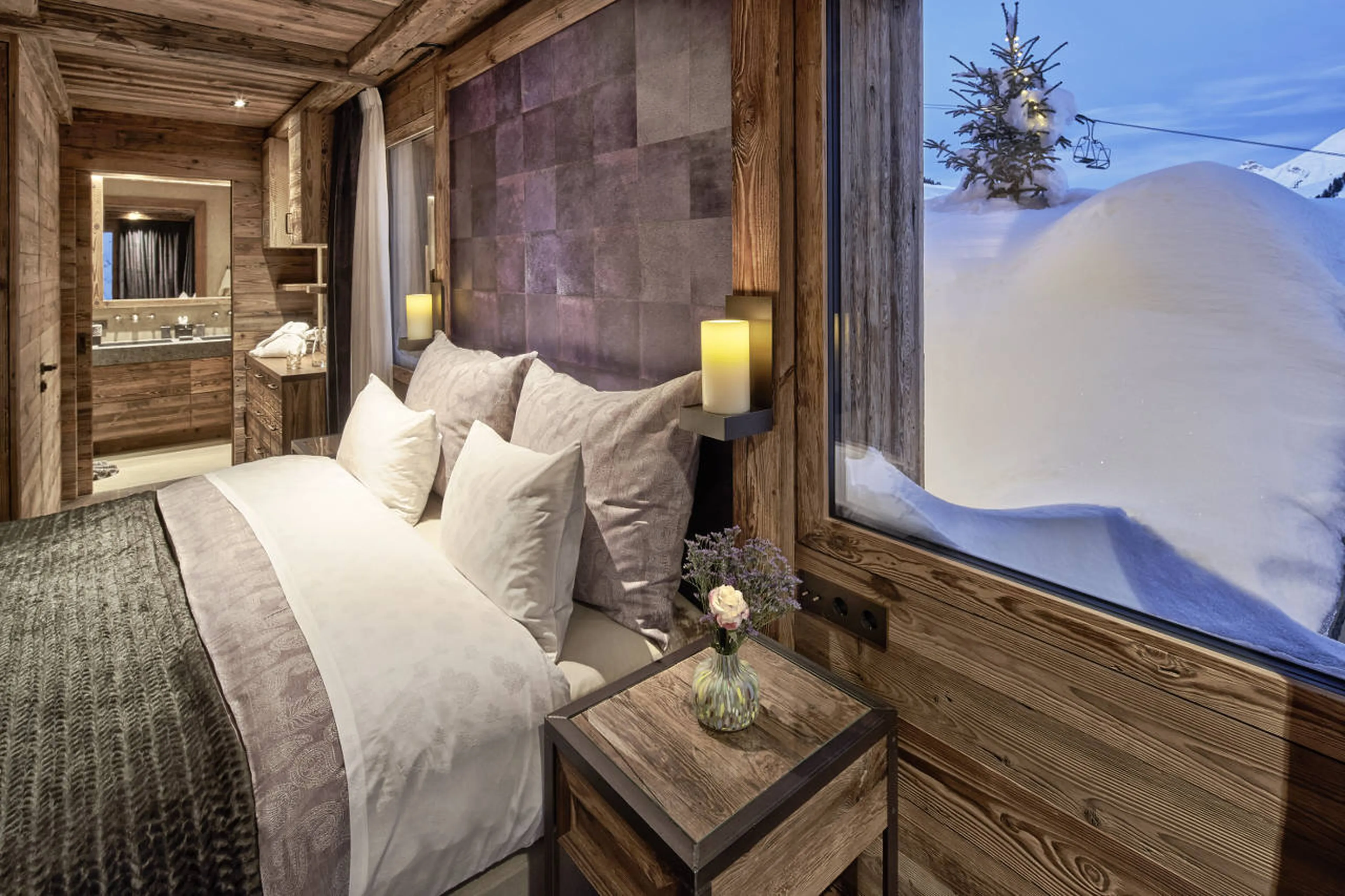 Queen-size bed in double bedroom with en-suite shower room in Chalet 1551 in Lech
