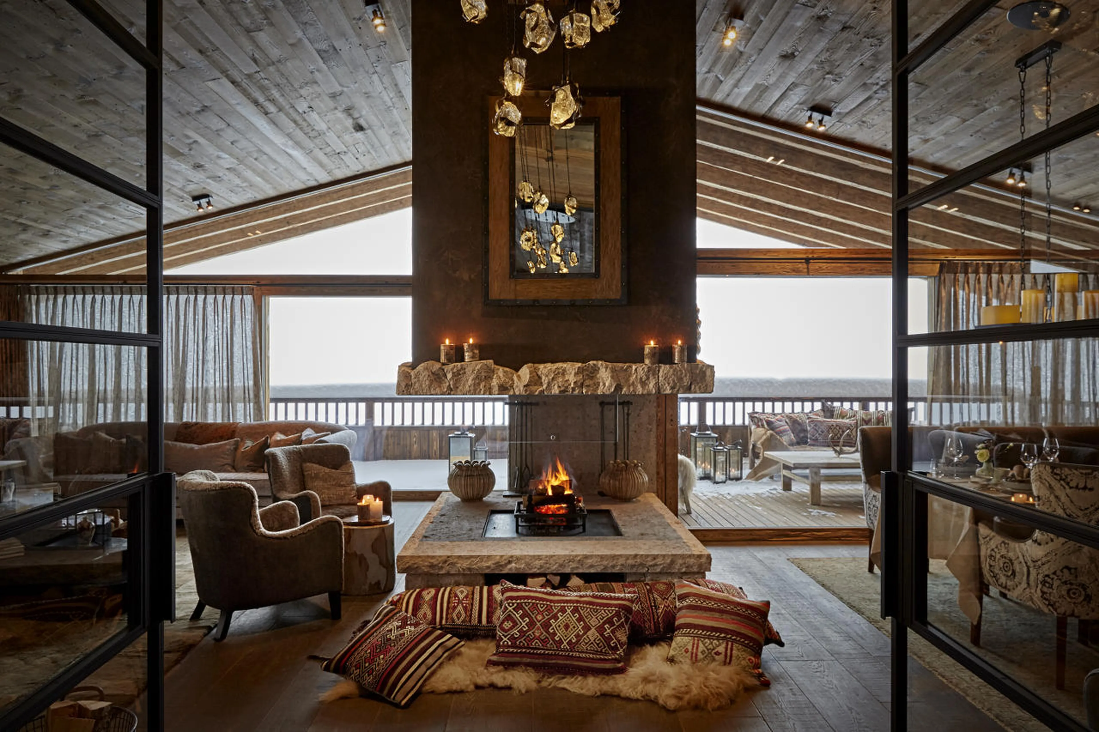 Living area with vaulted ceiling and central fireplace in Chalet 1551 in Lech