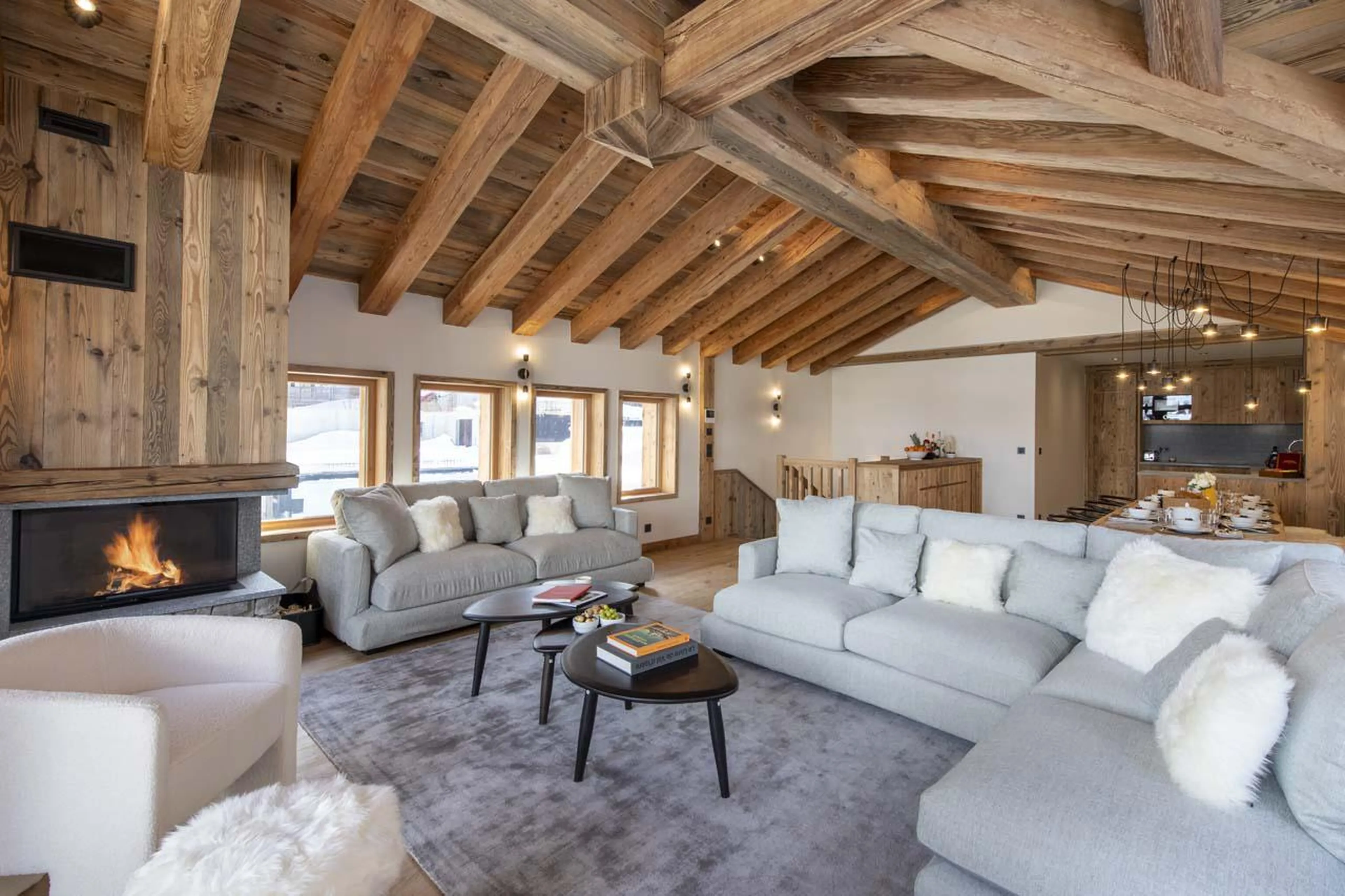 Comfortable sofa space surrounding the wood-burning fireplace at Chalet 1850 in Val d'Isere