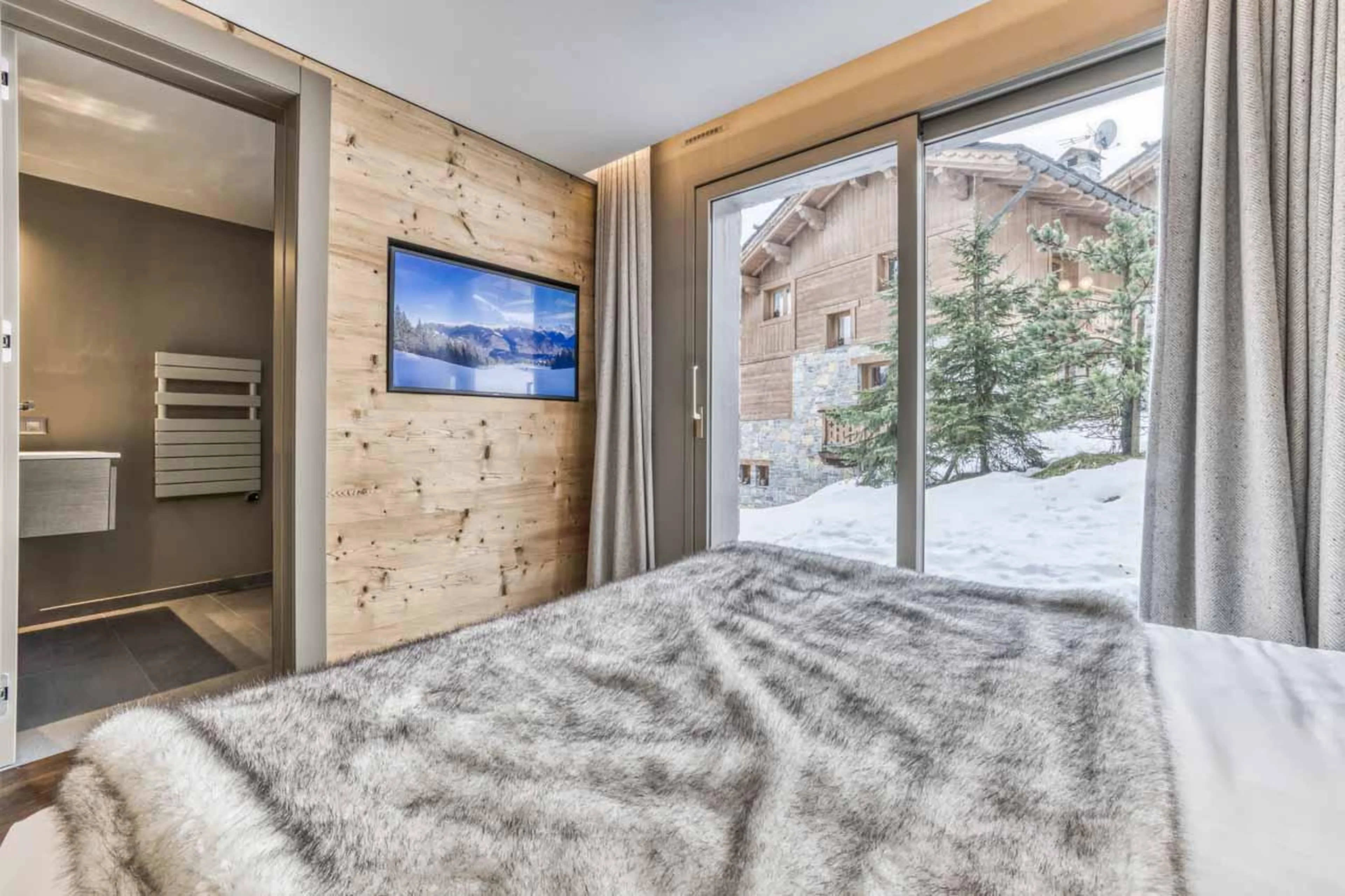 Double bedroom with floor-to-ceiling sliding doors at Chalet Acelia in Courchevel 1550