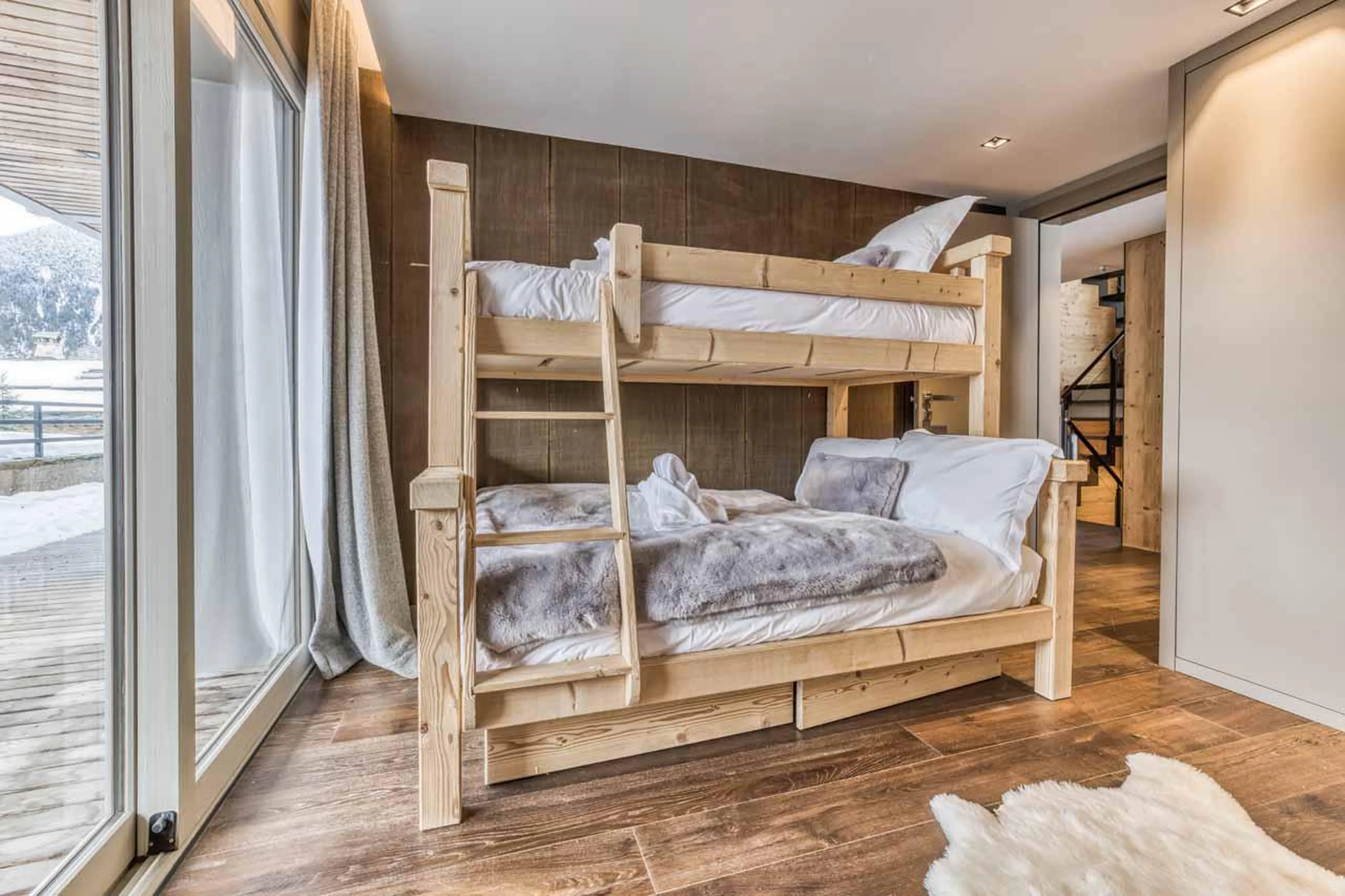 Double bunk bedroom with terrace access and en-suite shower room at Chalet Acelia in Courchevel 1550