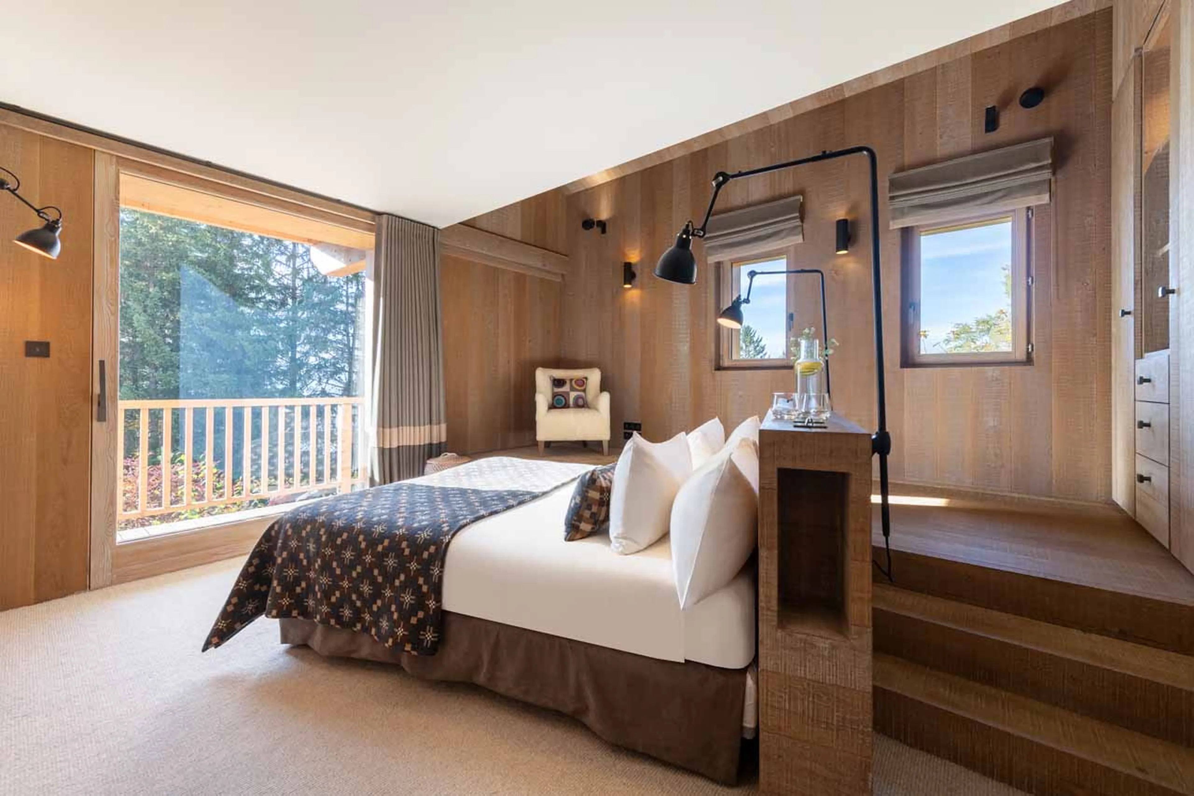 King-size bed and private balcony at Chalet Alpaca in Meribel