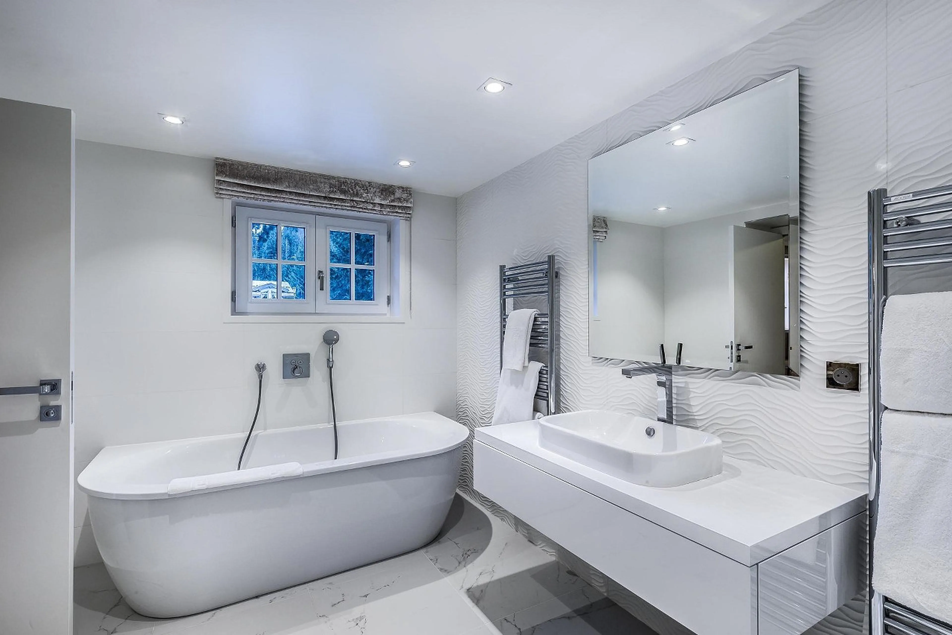 En-suite bathroom with bath and shower in Chalet Amnesia in Courchevel 1650