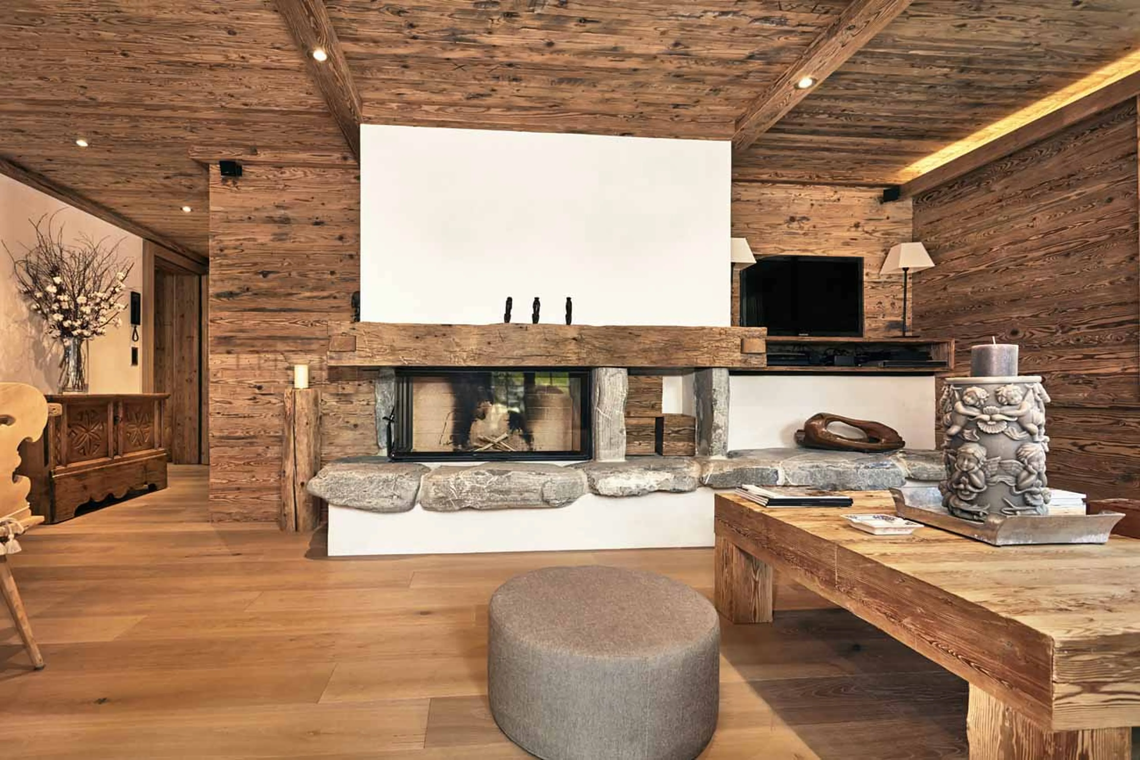 Fireplace & TV in living room at Chalet Amorica in Gstaad