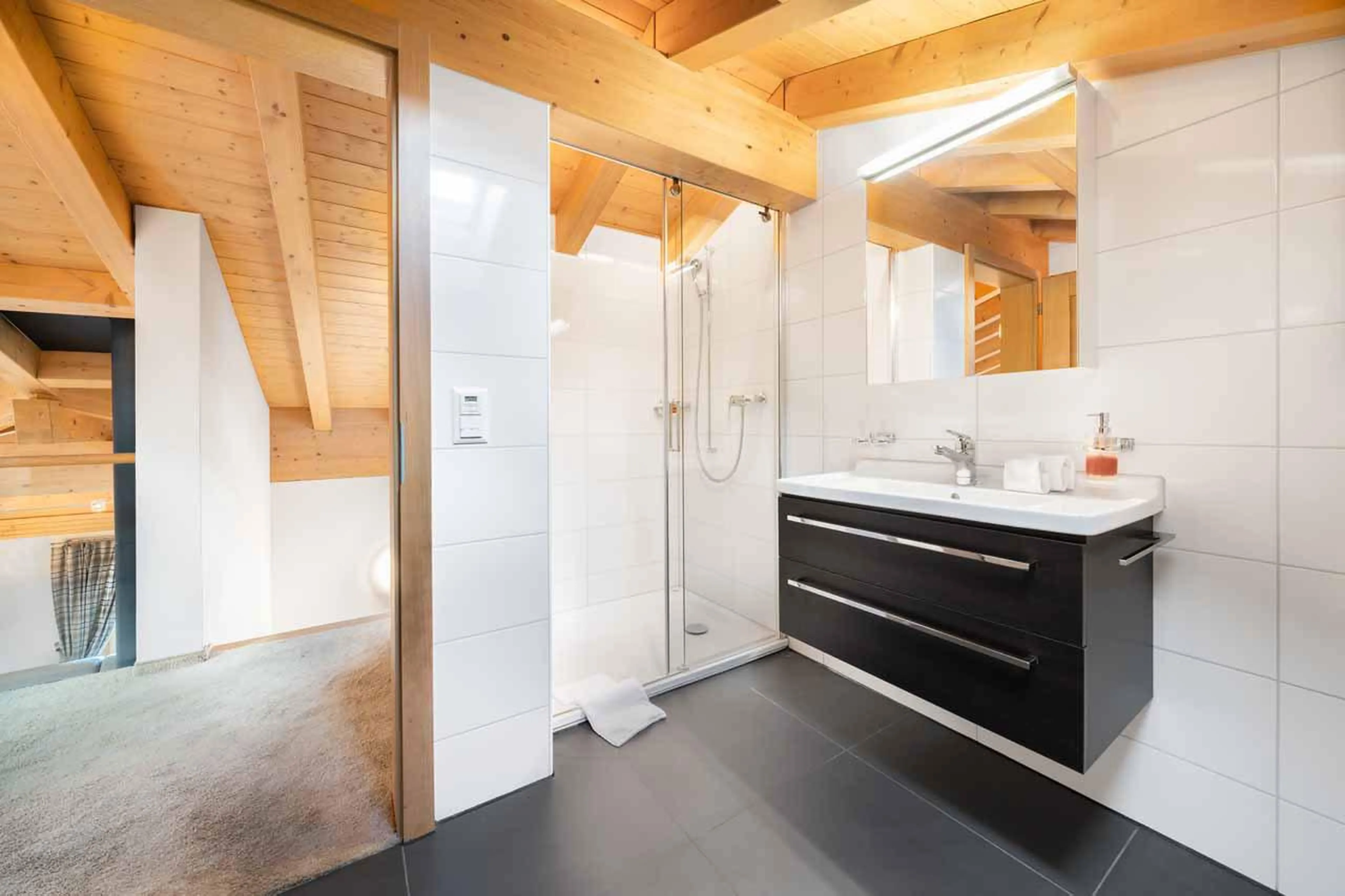 En-suite bathroom with bath and shower at Apartment Antara in Grindelwald