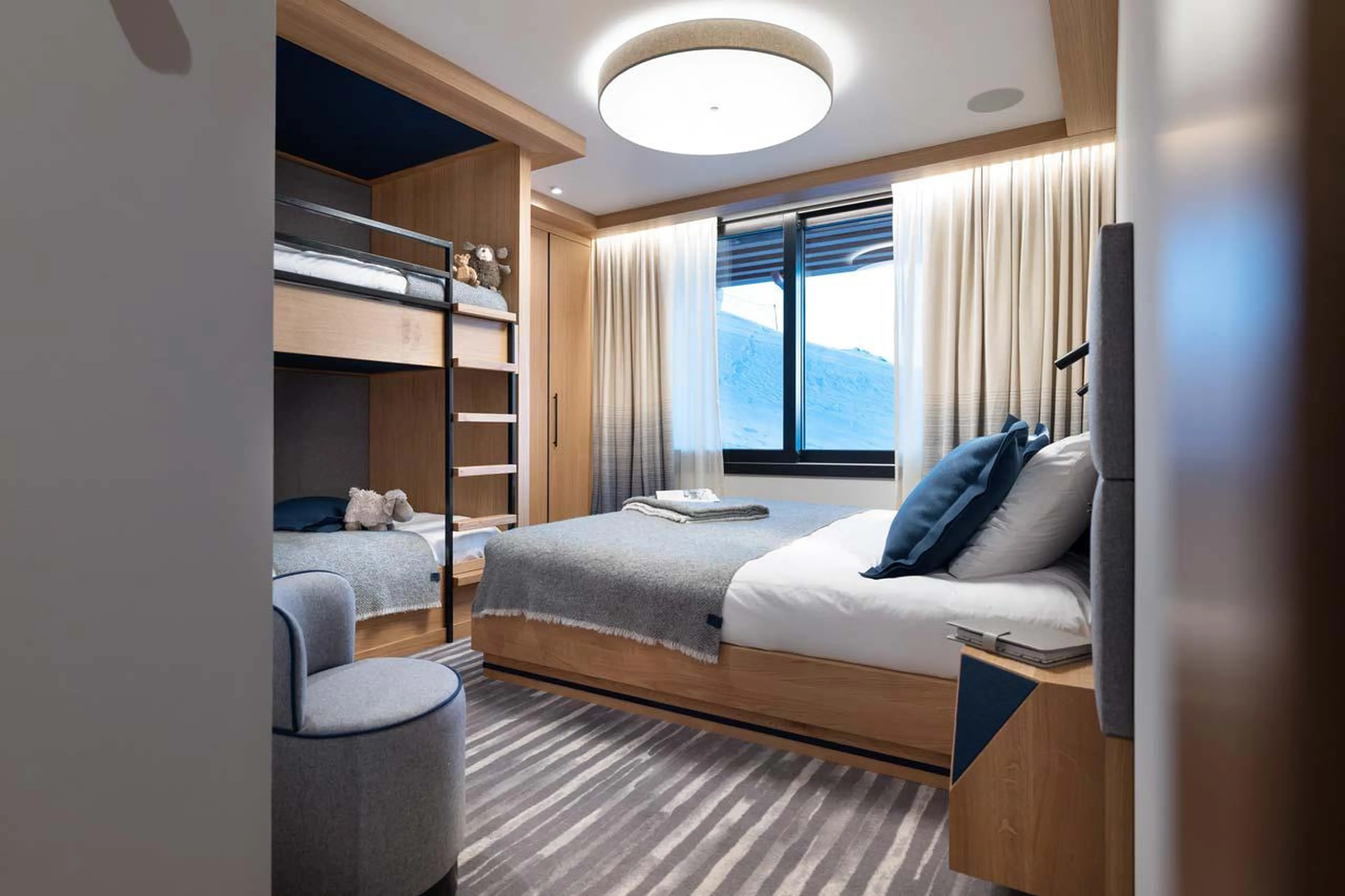 Family bedroom with king size bed and bunk beds at Chalet Arpoza in Les Arcs