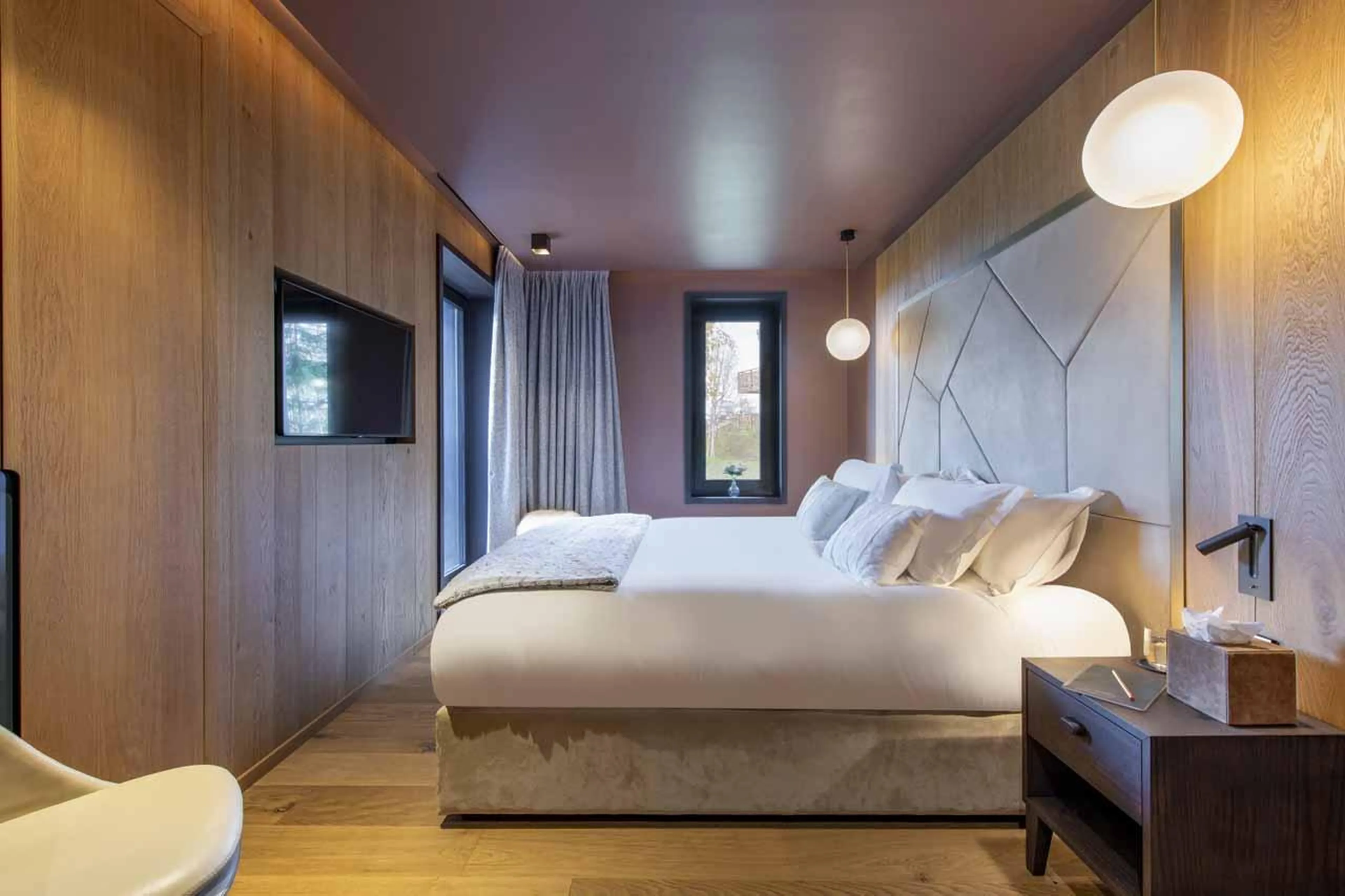 Double bedroom with chair and windows in Chalet Ascension, Courchevel 1650