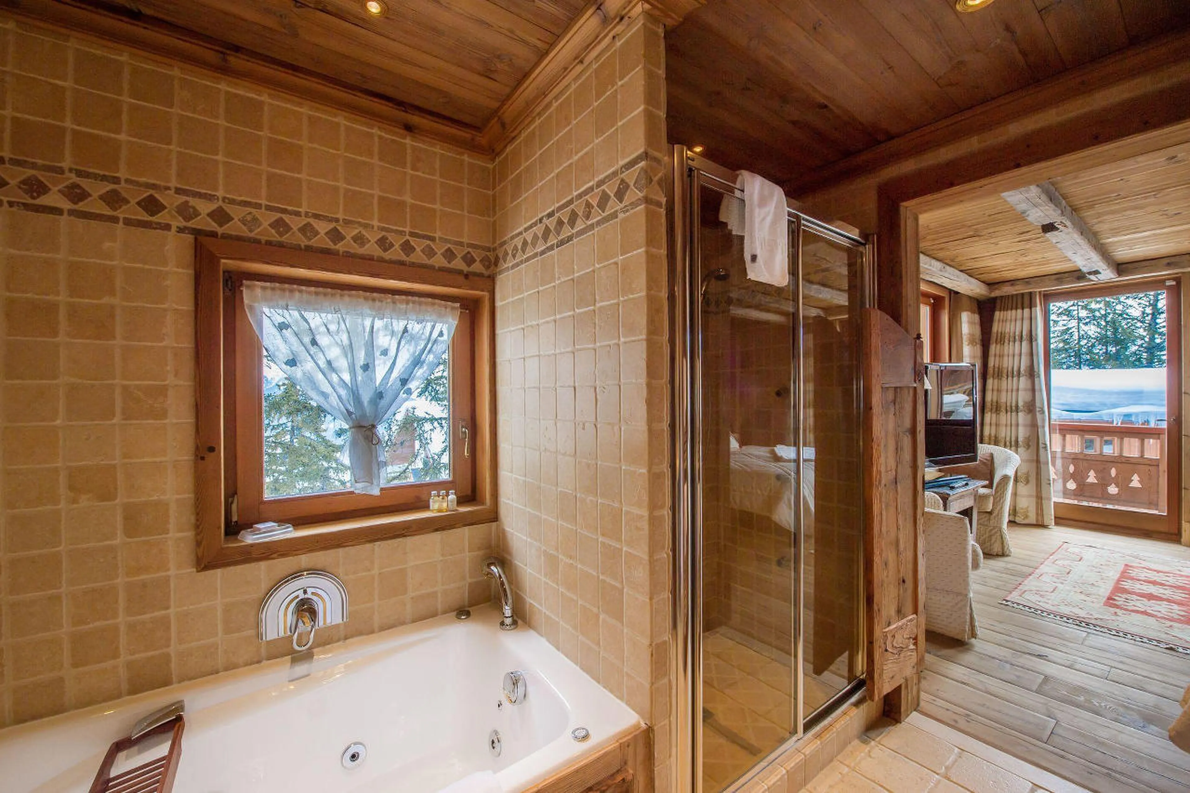 En-suite bathroom with whirlpool bathtub & separate shower at Chalet Aspen in Courcevel 1850