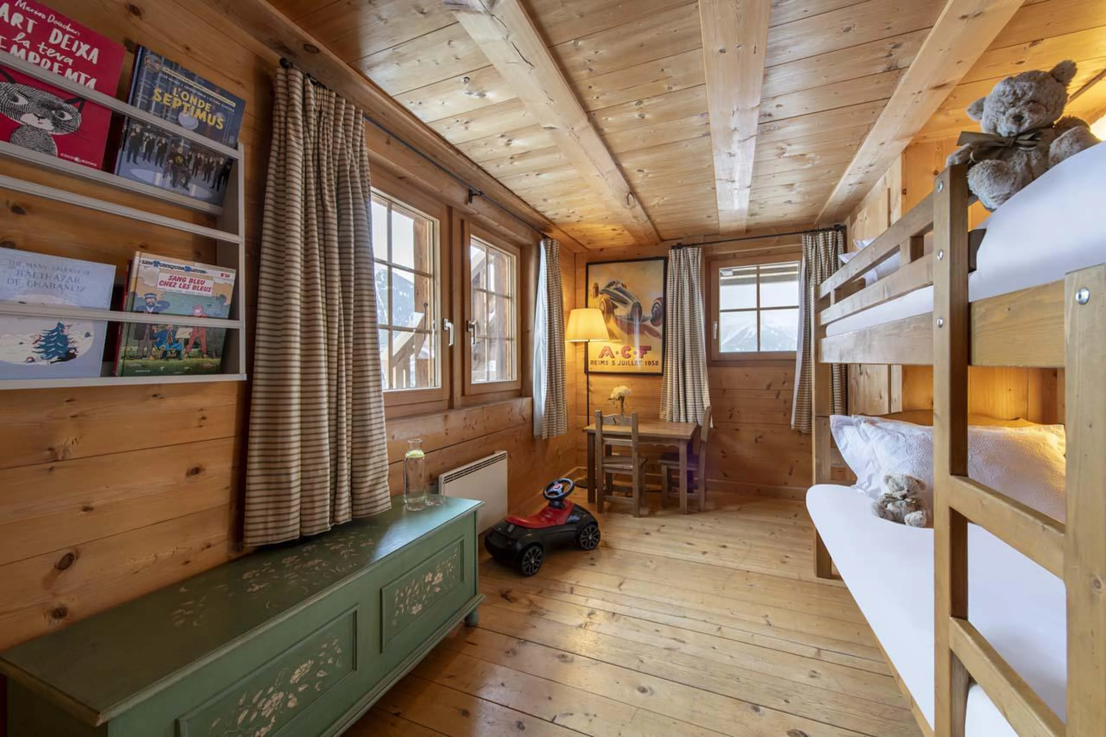 Bunk bedroom with table, books and mountain views at Chalet Bavaria in Verbier