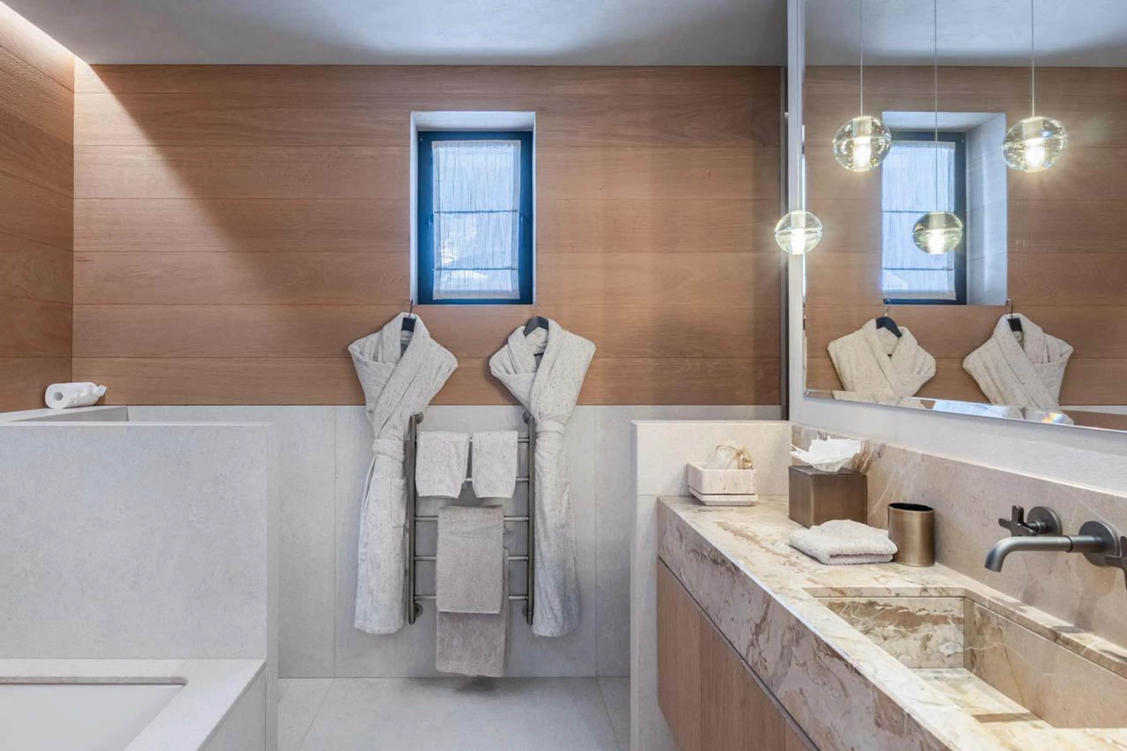 En-suite bathroom with bath and shower at Chalet Black Lodge in Courchevel 1850