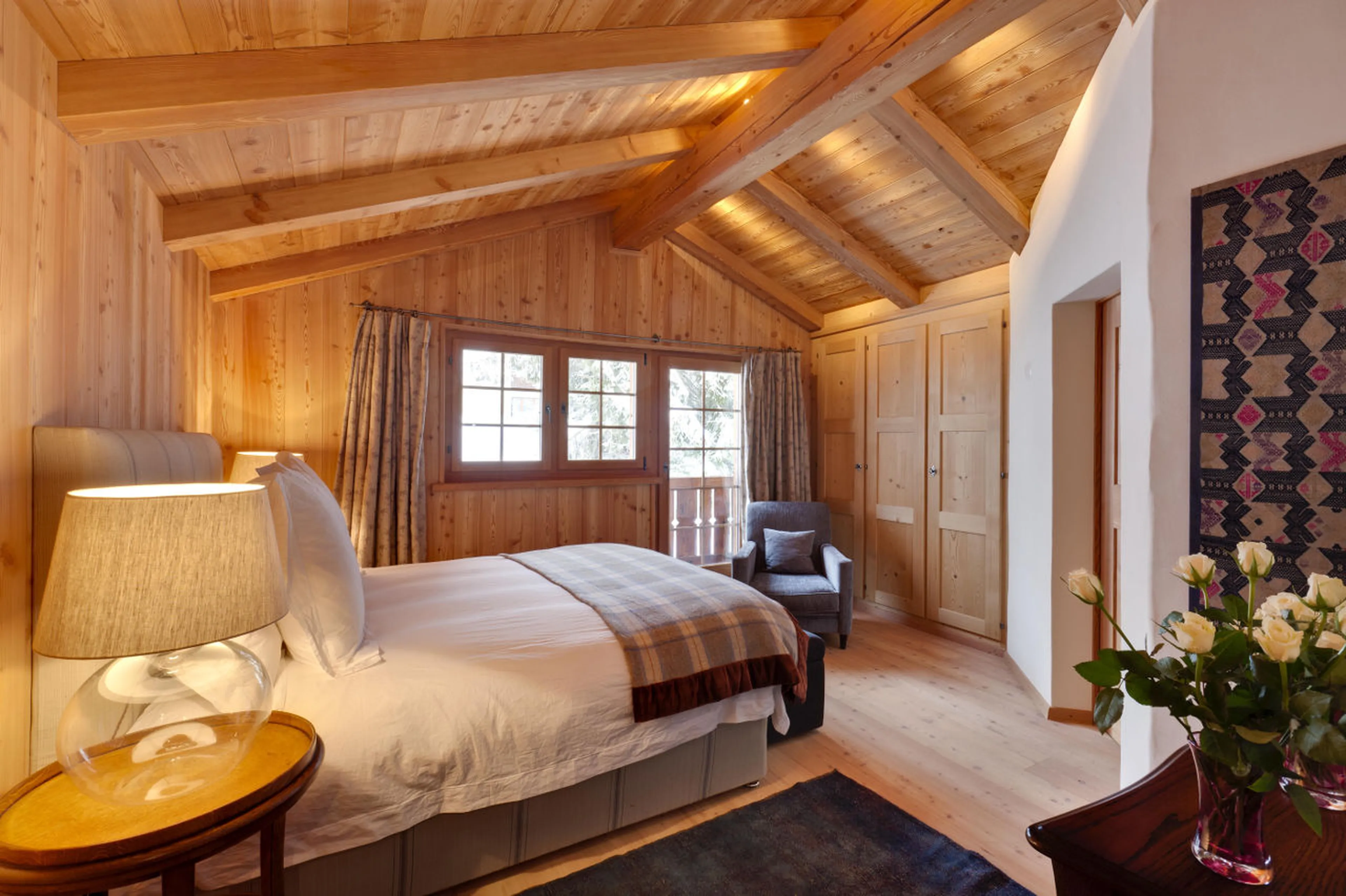 Double bedroom with en-suite shower room and balcony access in Chalet Chimera in Klosters