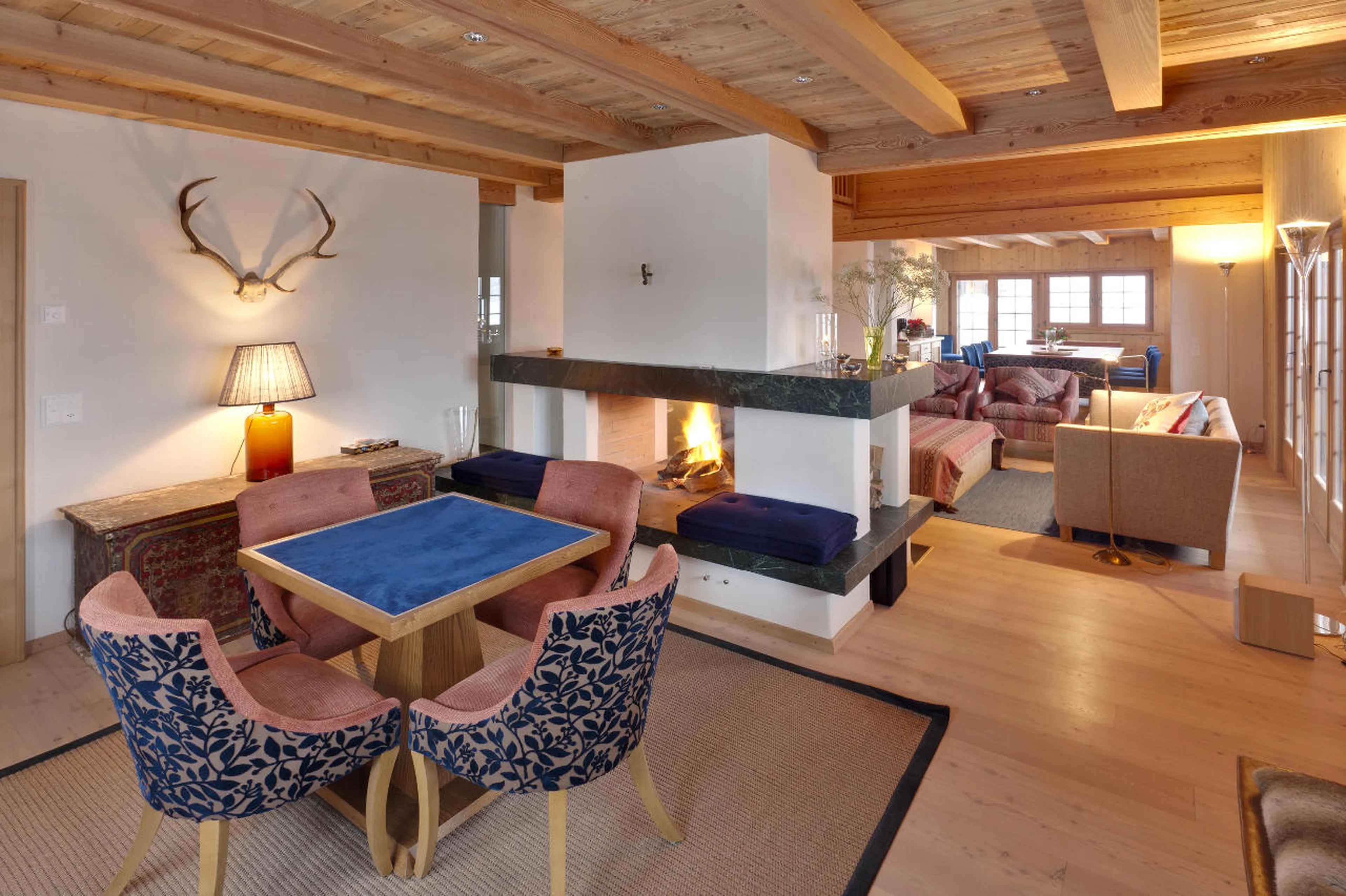 Double sided fireplace divides games and living areas in Chalet Chimera in Klosters