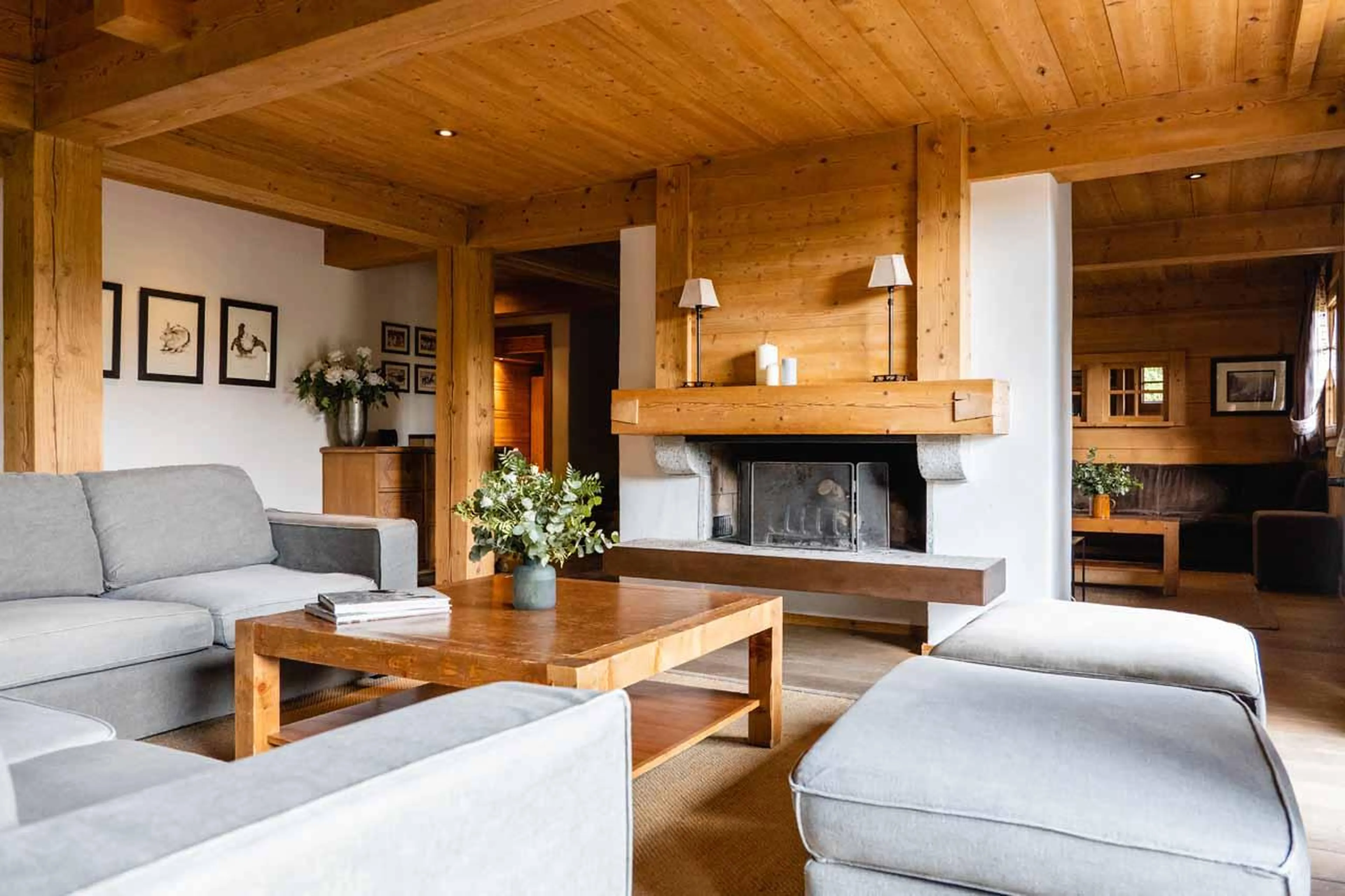 Sofas and coffee table arranged around fireplace  in Chalet Clovis, Megeve