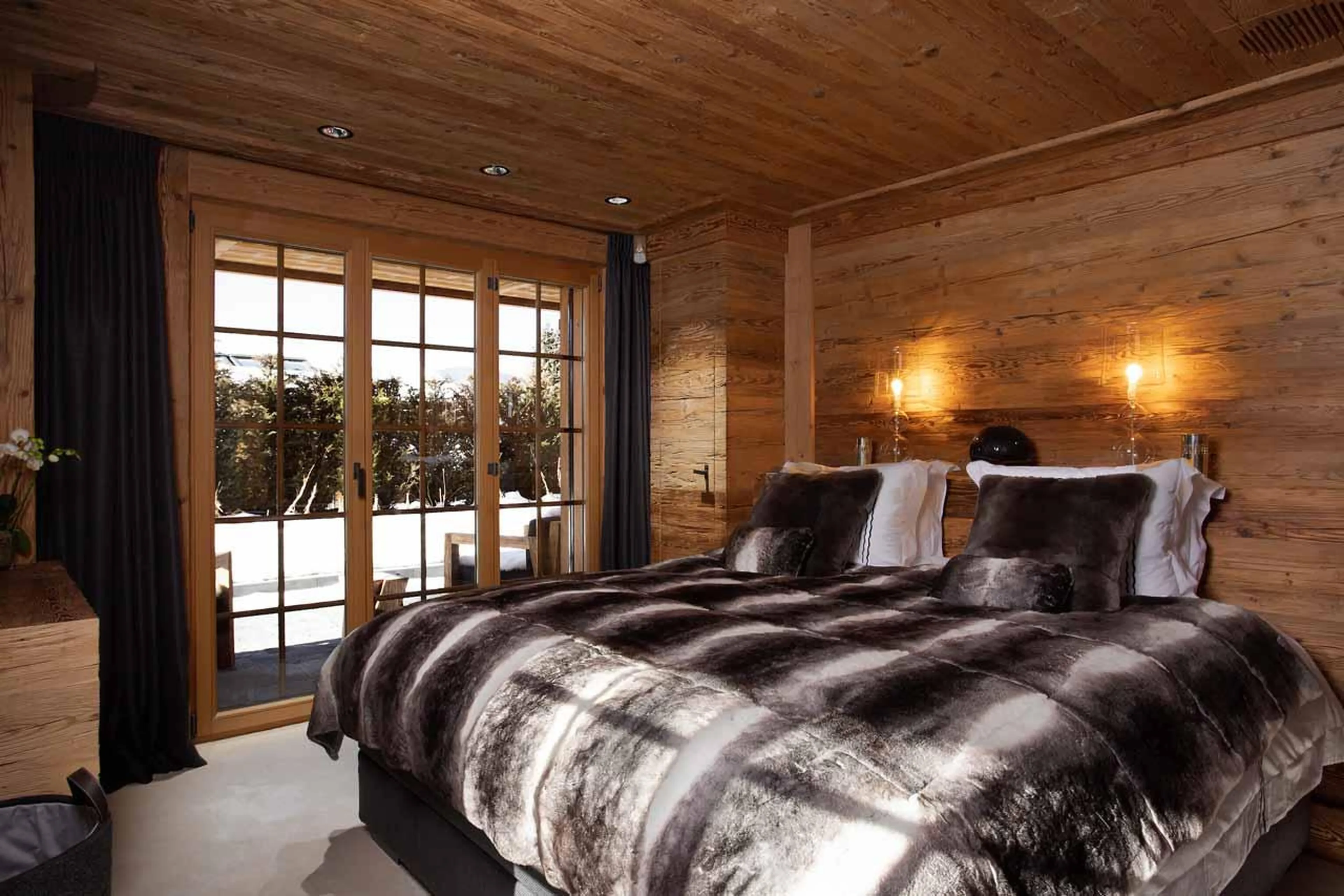 Double bedroom with balcony access and en-suite bathroom in Chalet Colombe, Gstaad
