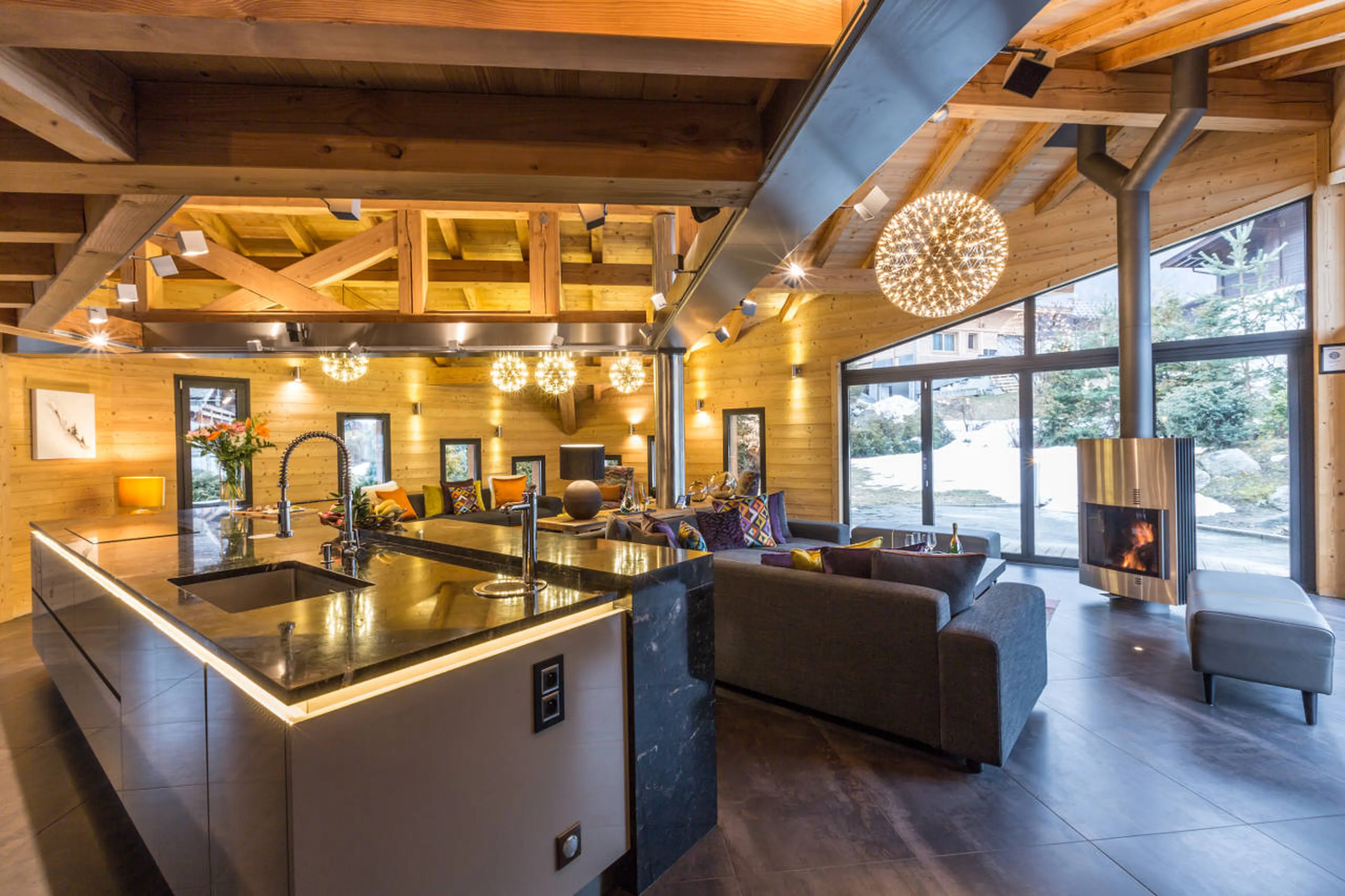 Living area with fireplace and open kitchen in Chalet Couttet in Chamonix