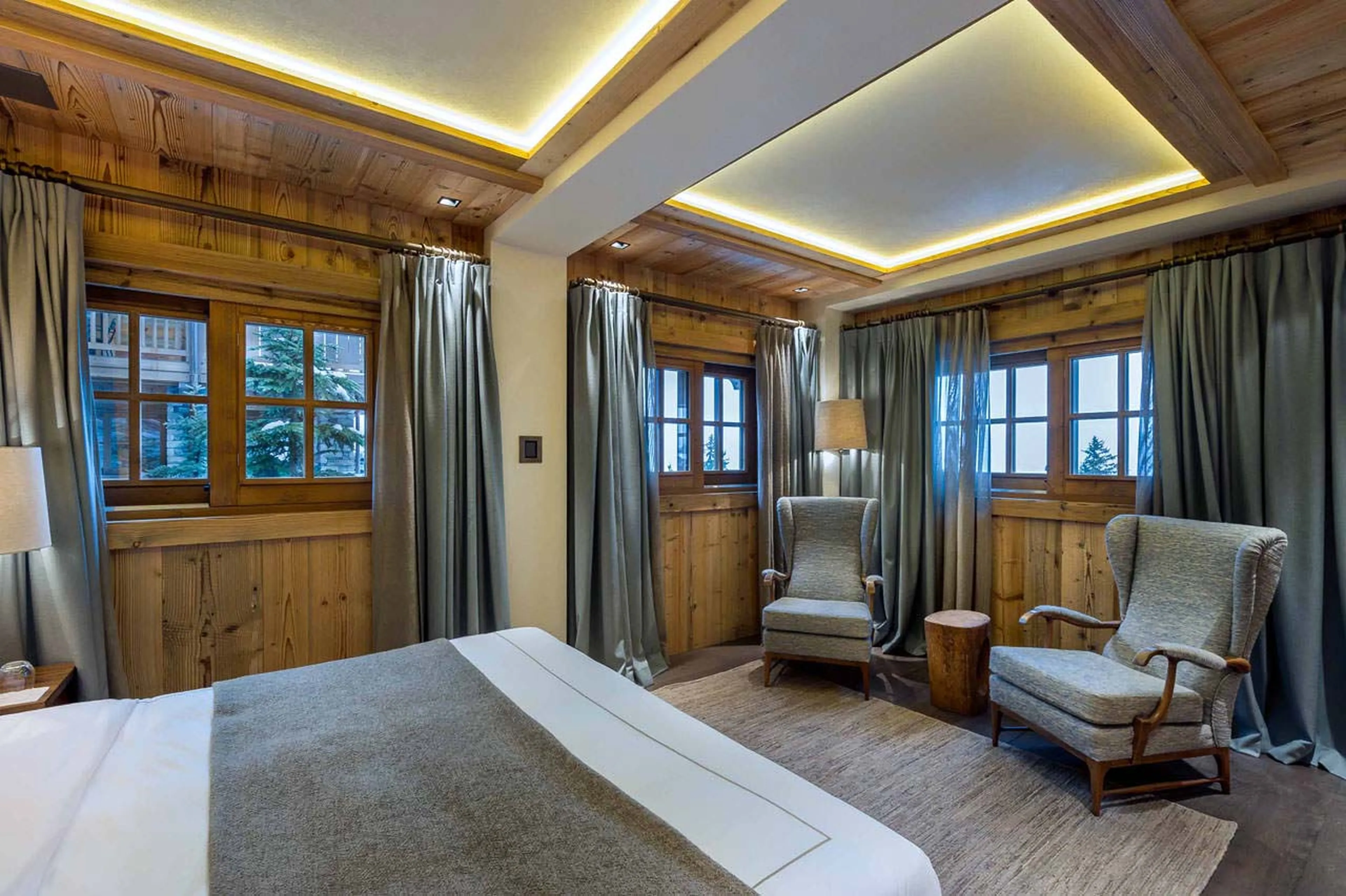 Double bedroom with wingback chairs and a view in Chalet Cryst'Aile in Courchevel 1850