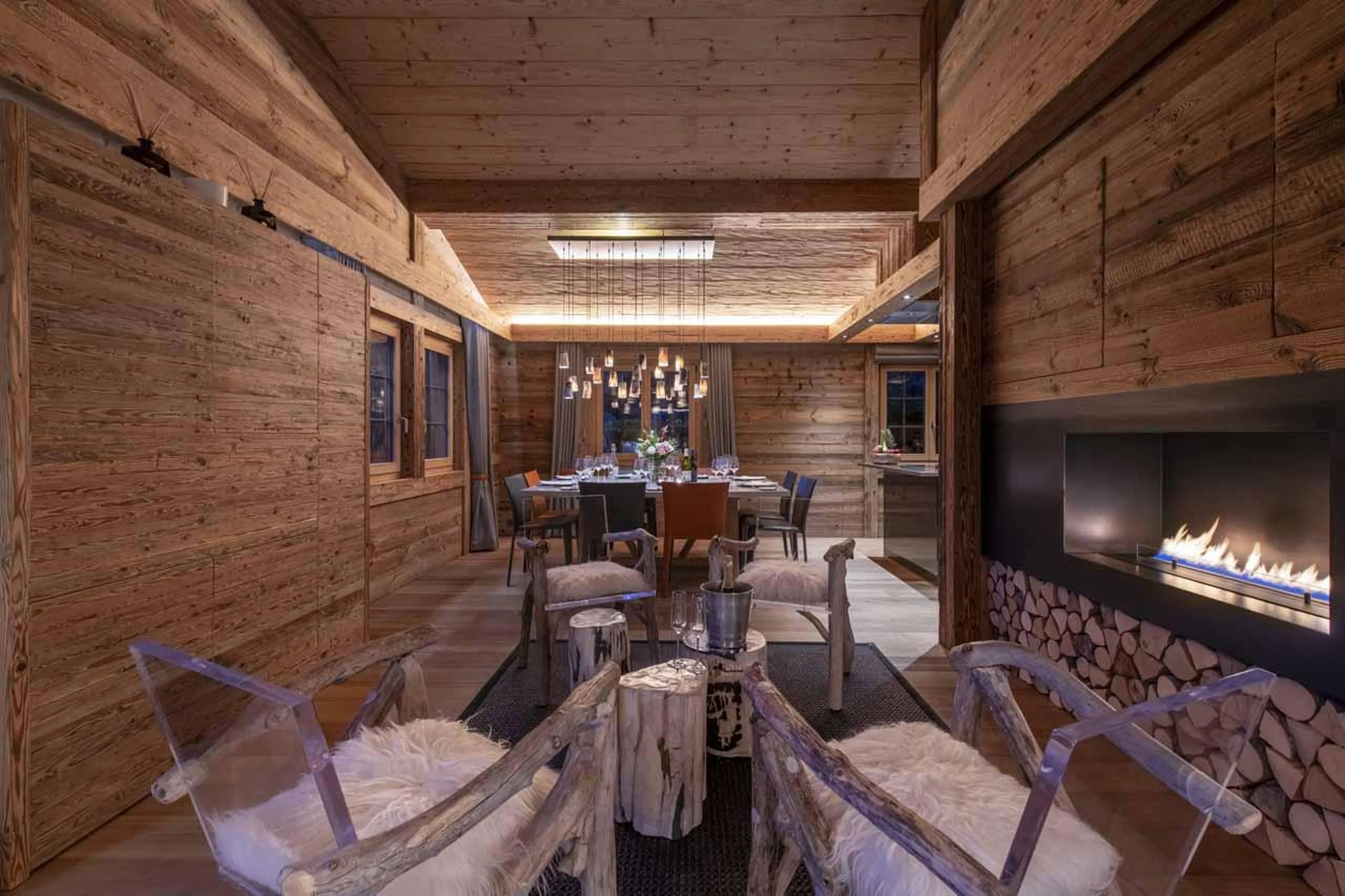 Armchairs by fireplace in living area of Chalet Daphne in Verbier