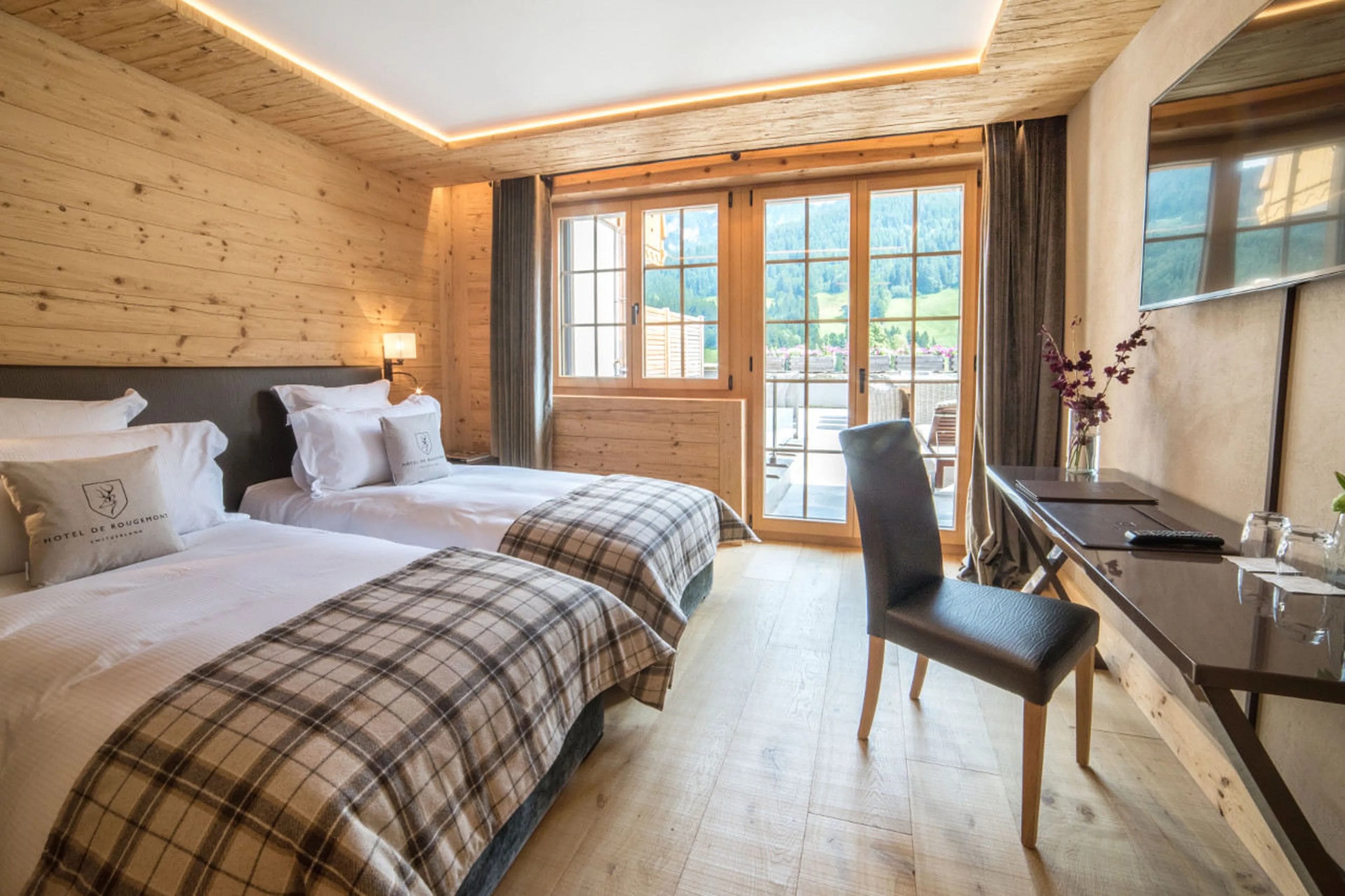 Double/twin bedroom with en-suite bathroom and terrace access in Chalet de Rougemont in Gstaad