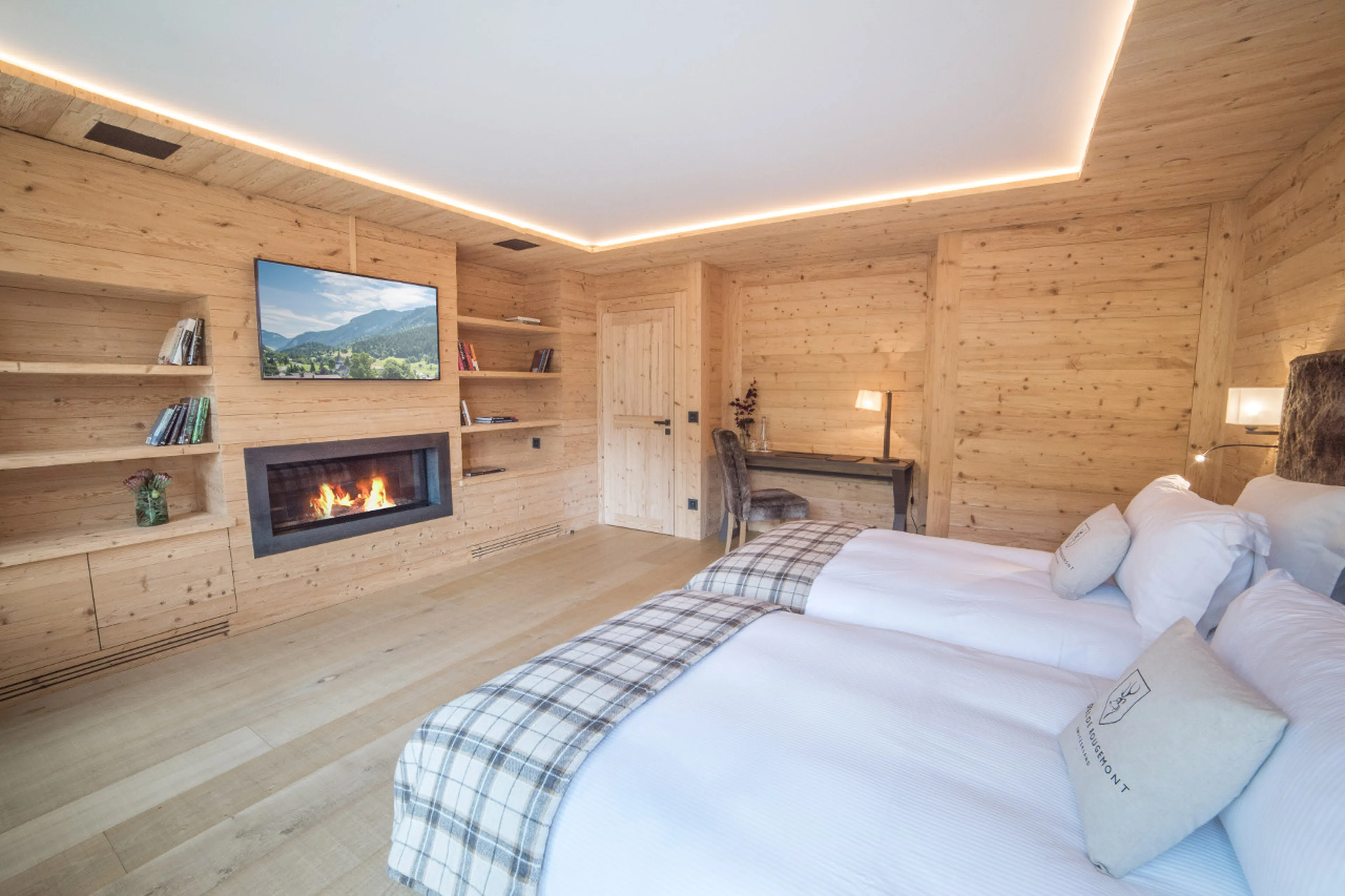 Bedroom with twin/double bed, fireplace and terrace entrée in Chalet de Rougemont in Gstaad
