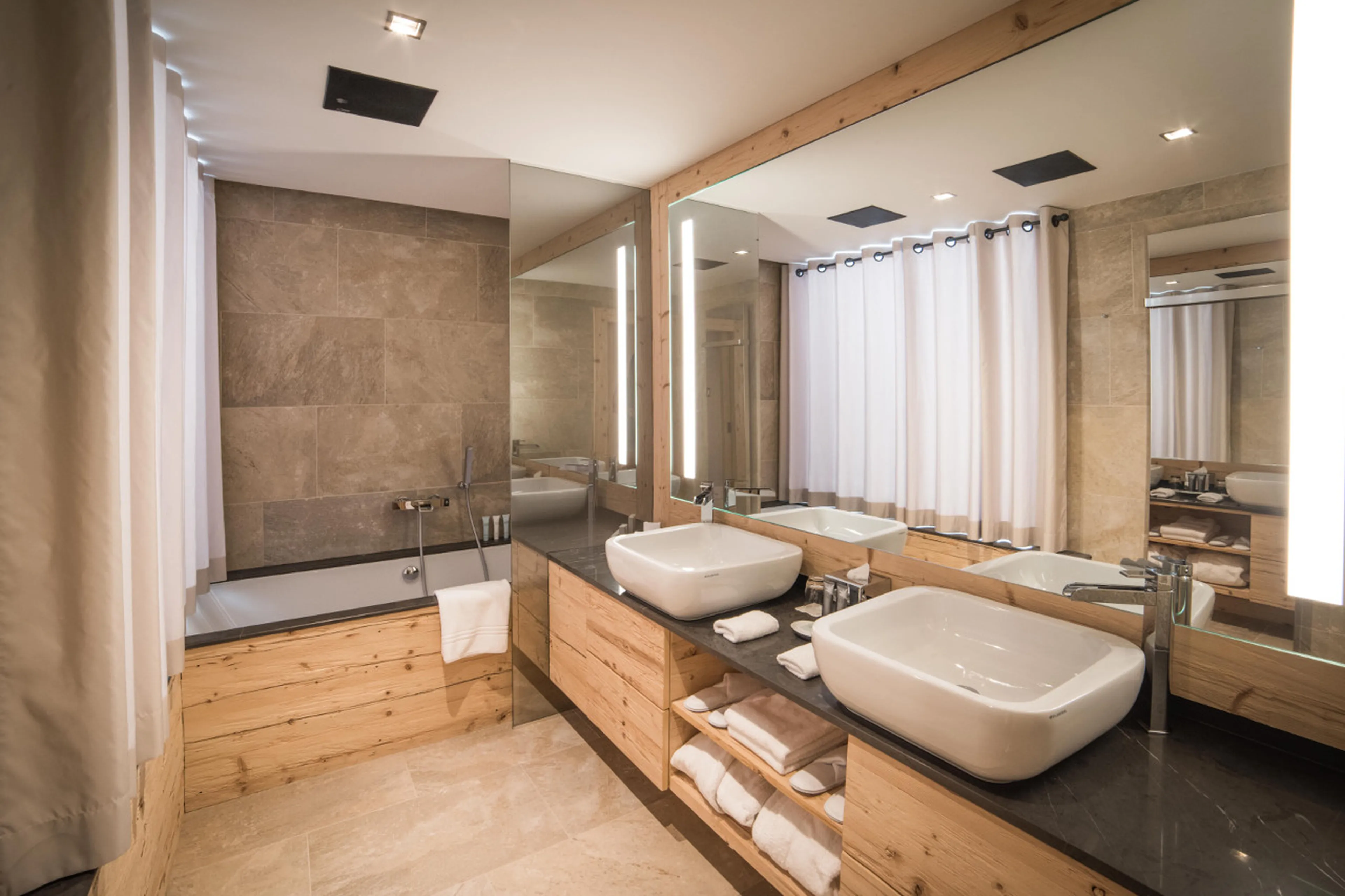 En-suite bathroom with bath tub and double basin in Chalet de Rougemont in Gstaad