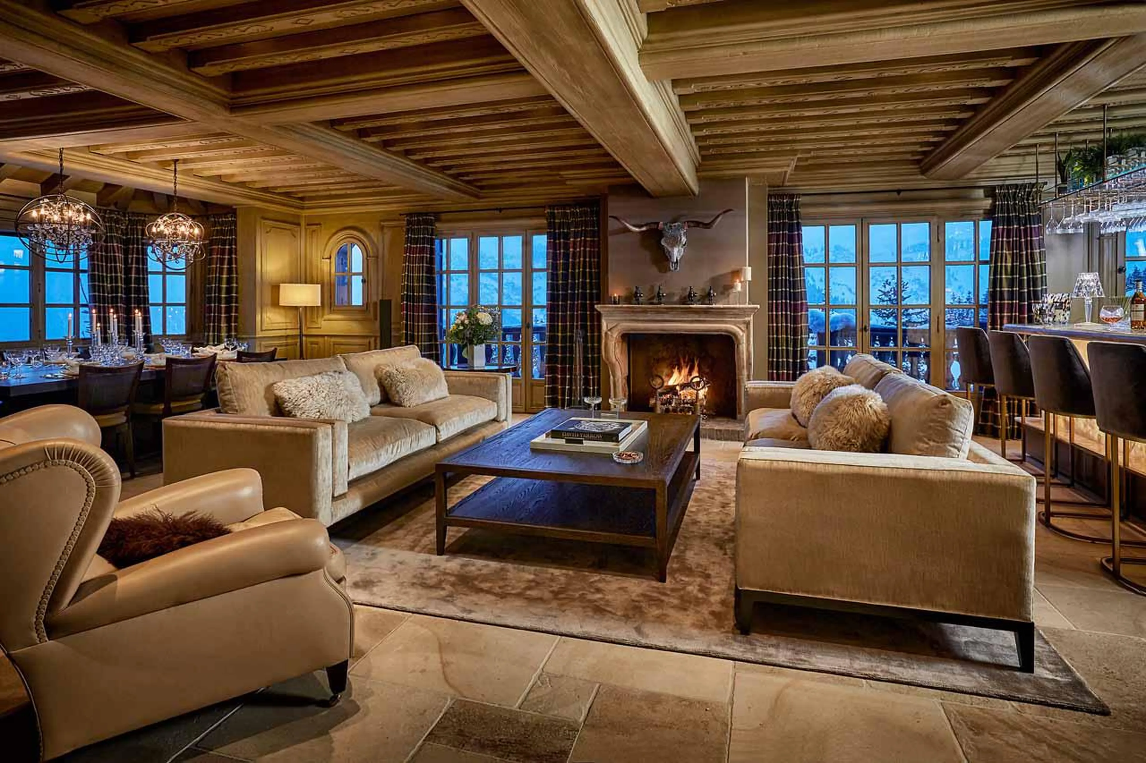 Lounge in open-plan living area with fireplace and sofas in Chalet d'Ecosse, Courchevel 1850