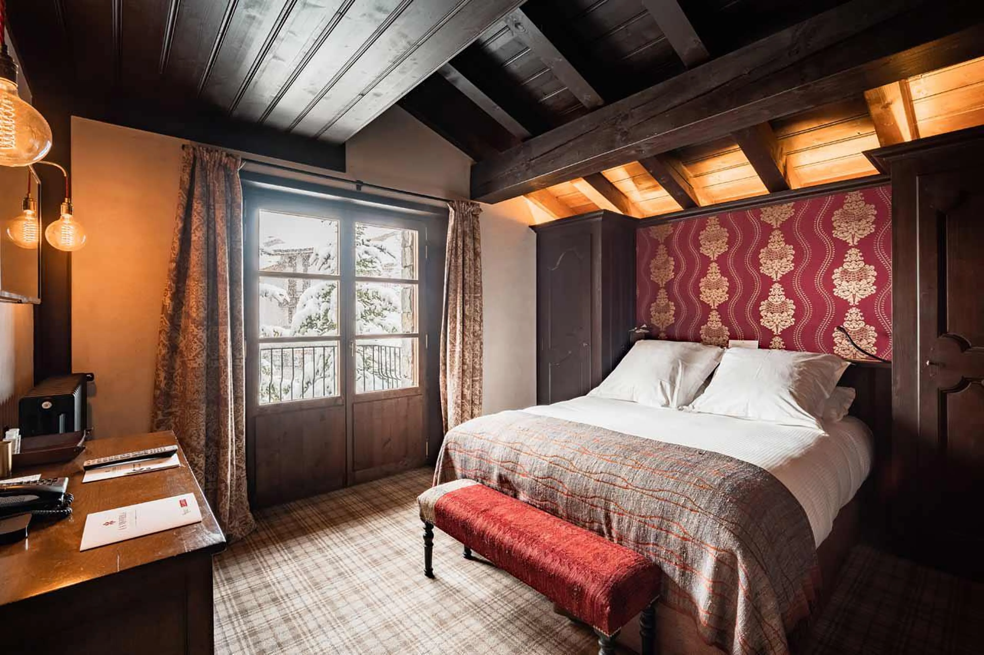 Bedroom with double bed and balcony access in en suite bedroom in Chalet Ebene in Val d’ Isere
