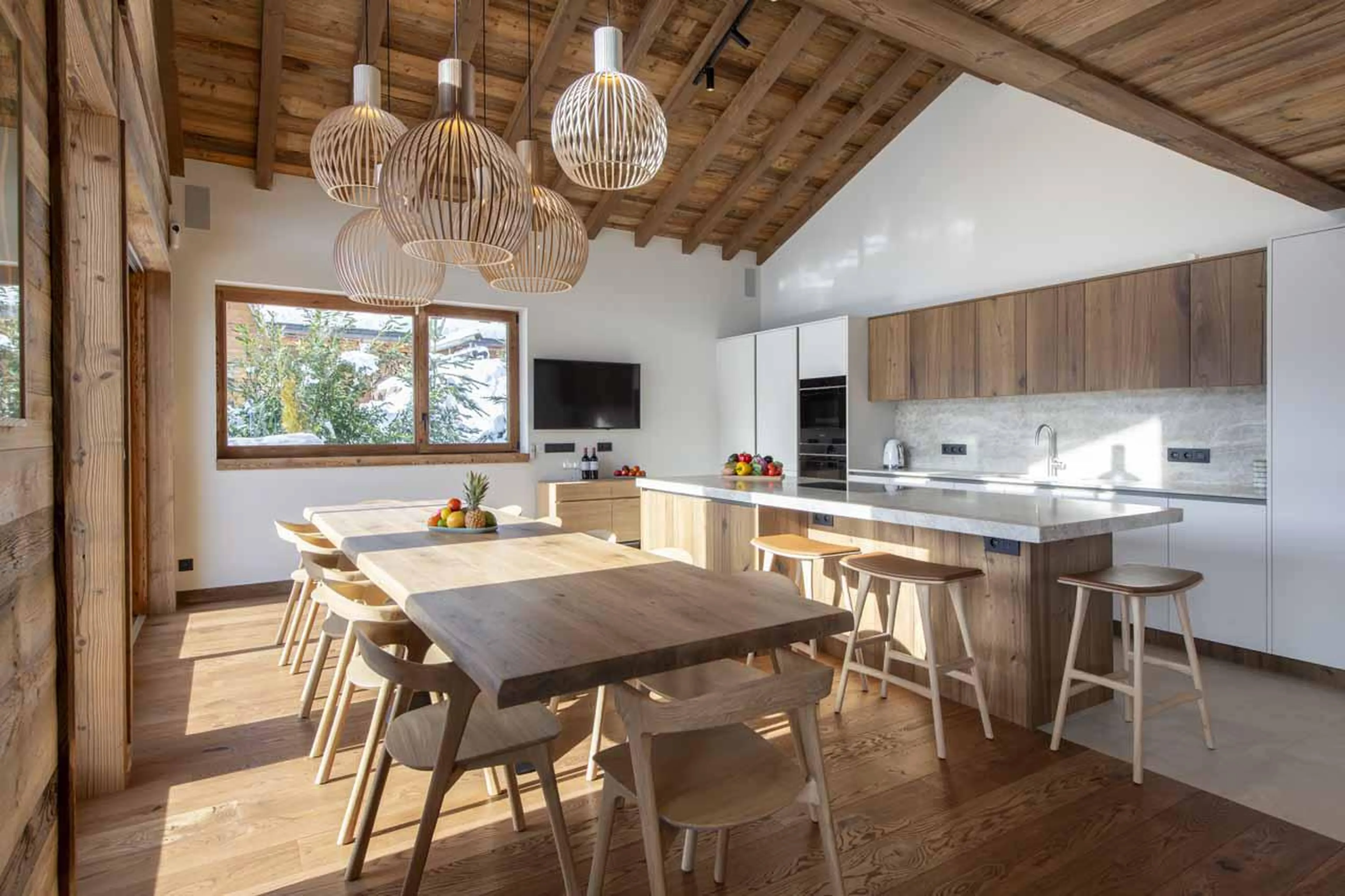 Dining table and kitchen with island in Chalet Fika, Les Gets