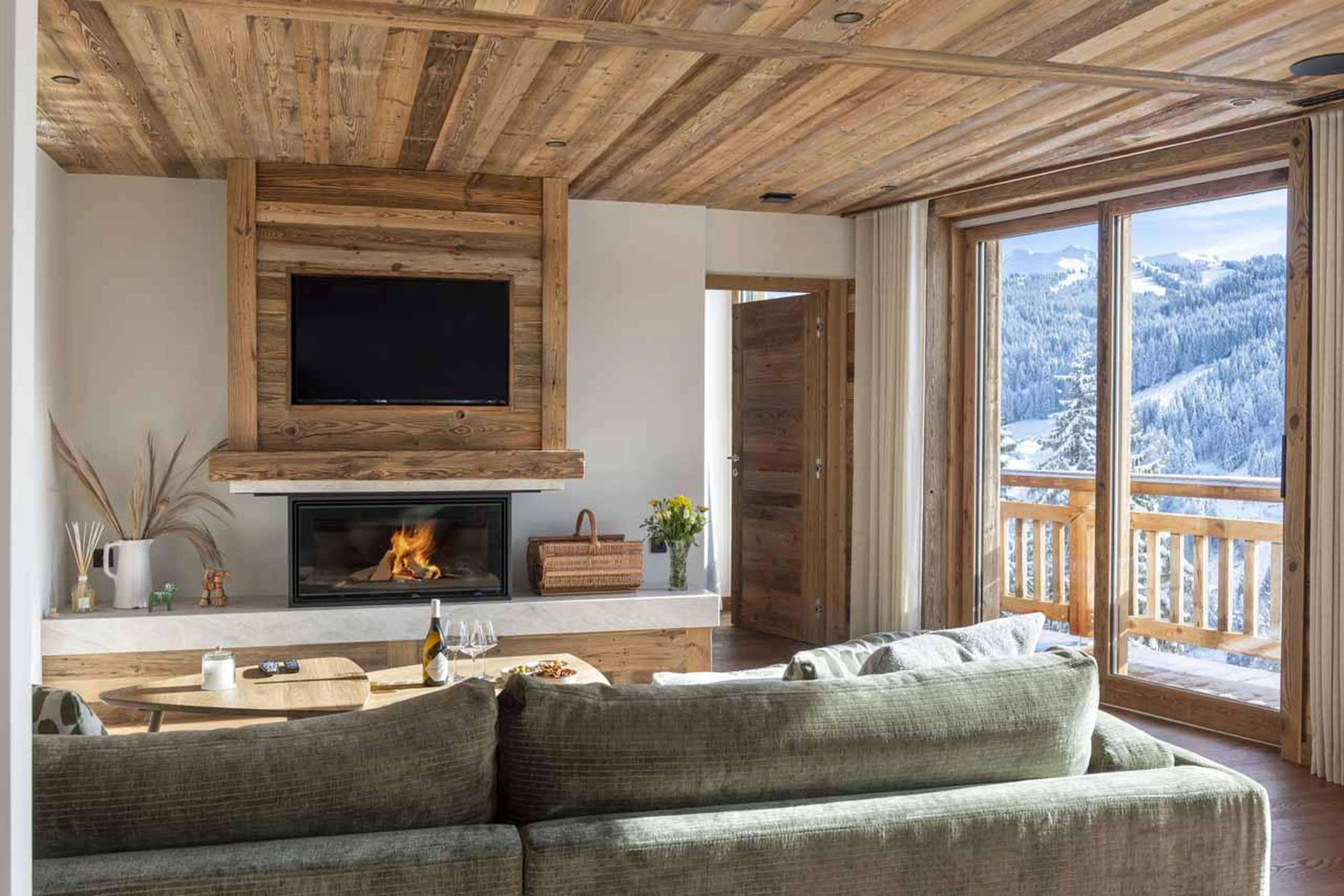 Sofa set in front of wood burning fireplace in Chalet Fika, Les Gets