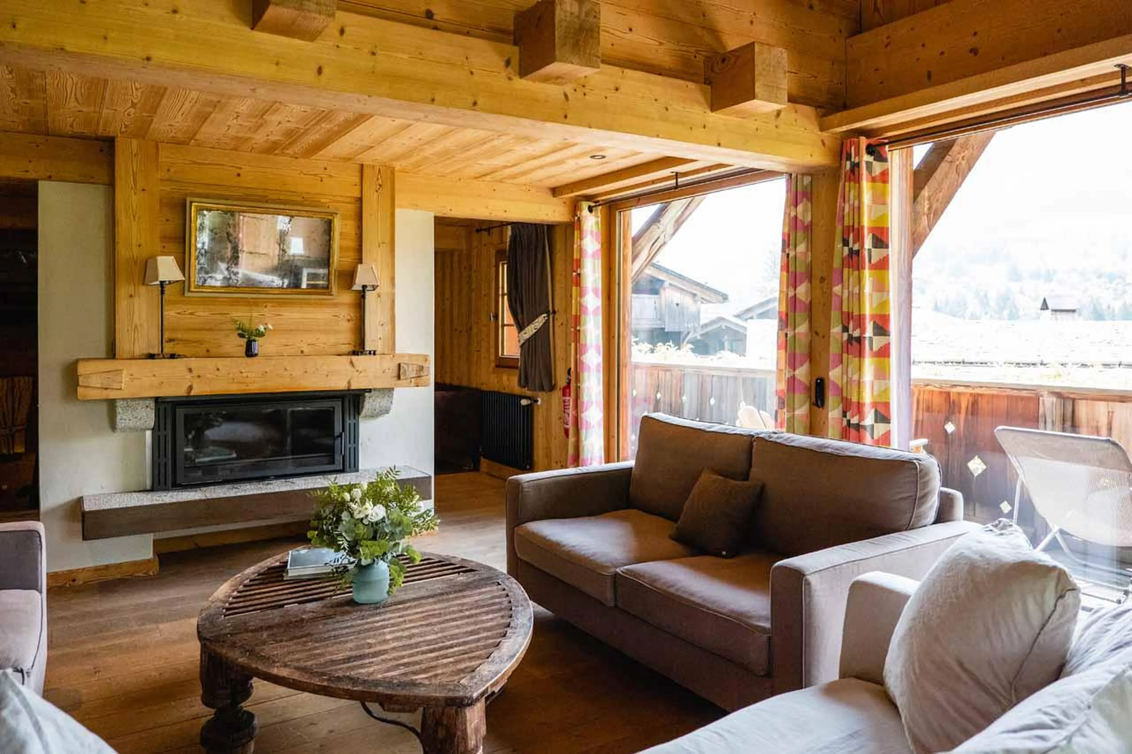 Sofas and armchairs in front of a fireplace in Chalet Firmin, Megeve