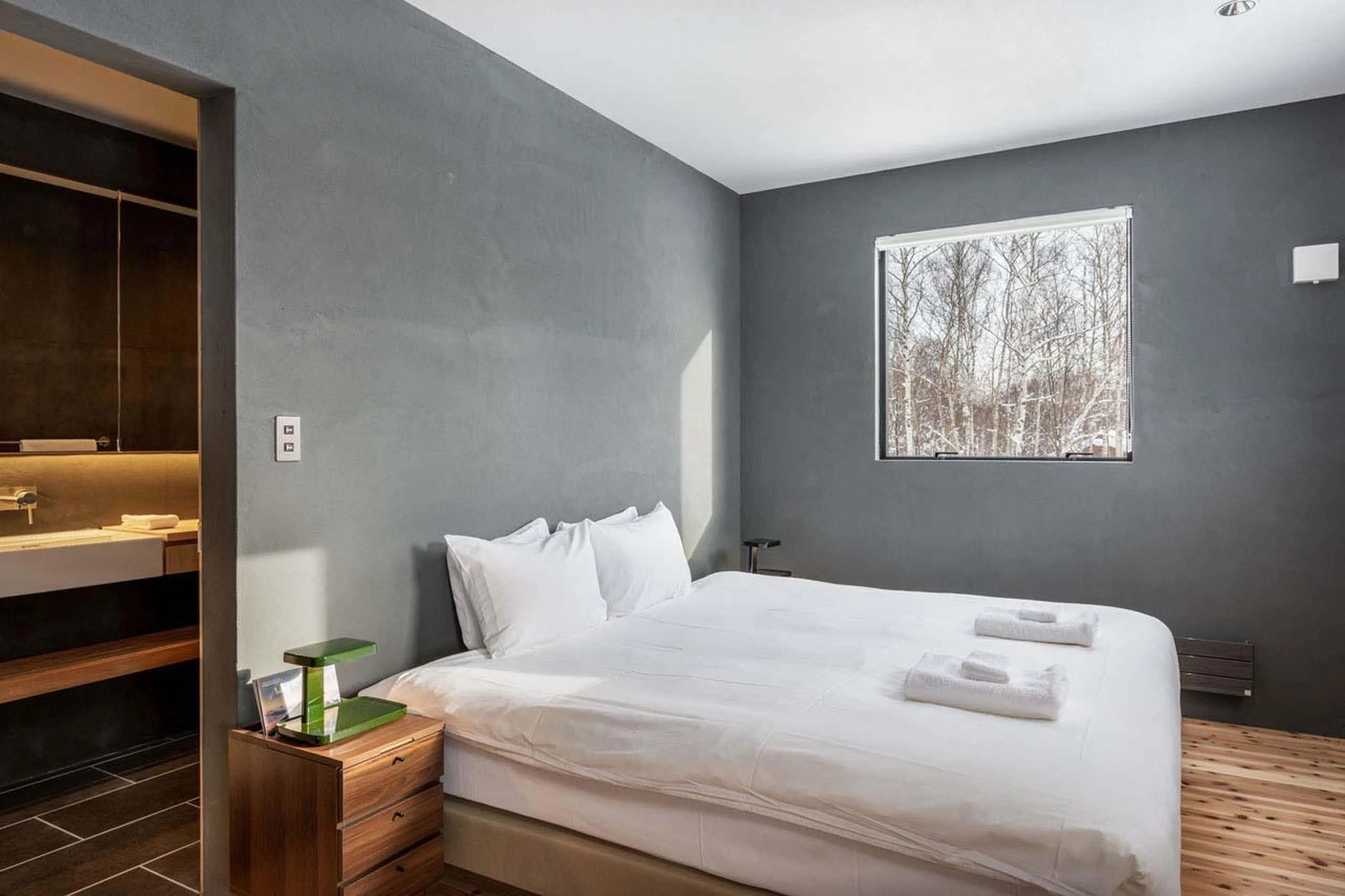 Bedroom with window framing snowy mountain views at Chalet Foxwood B in Niseko